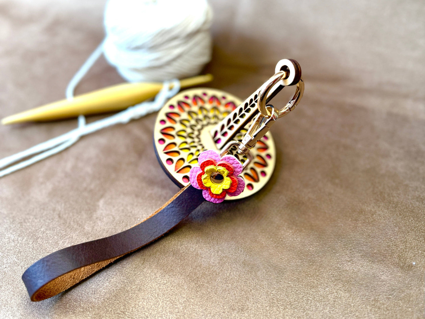El Corazon wooden yarn accessory by Lemonwood circular carved yarn minder with leather strap and felt flower charm