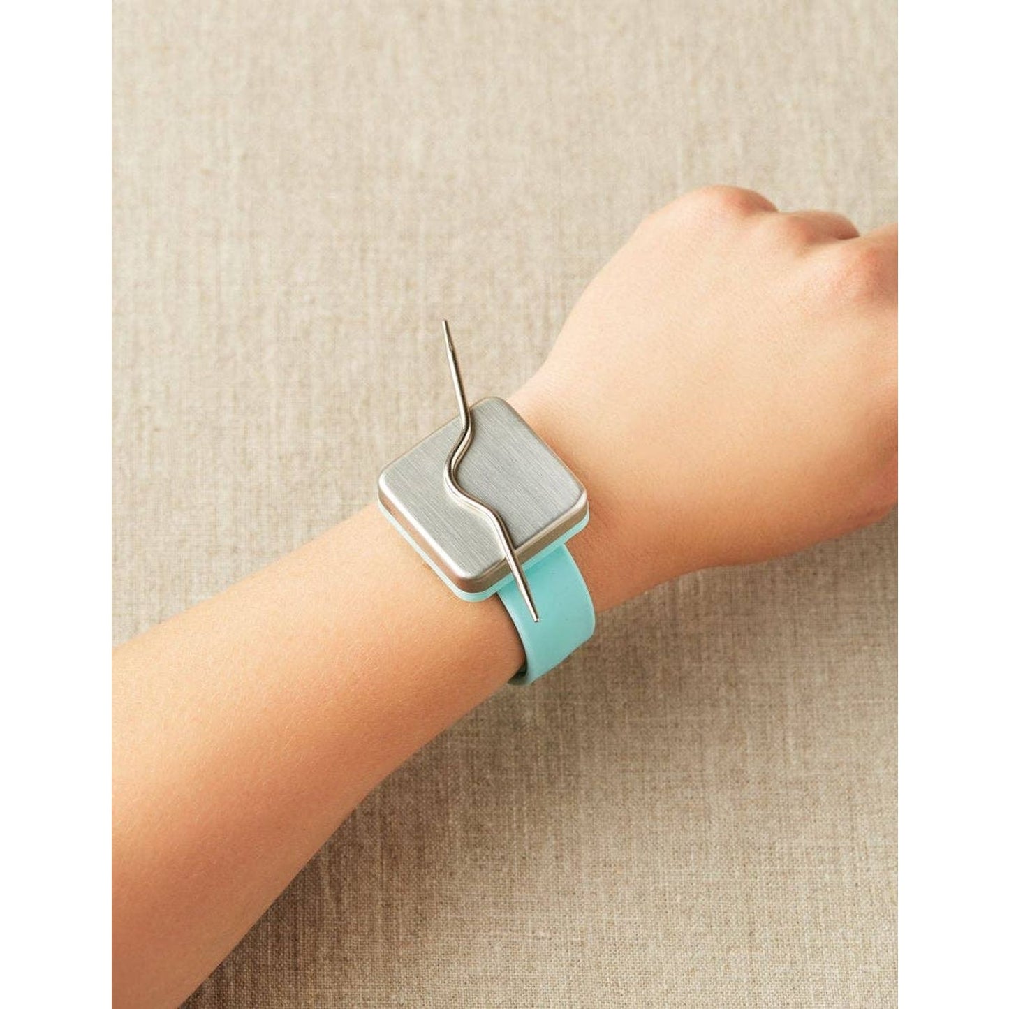 Cocoknits curved cable needles for knitting displayed on a wrist, featuring a stylish design