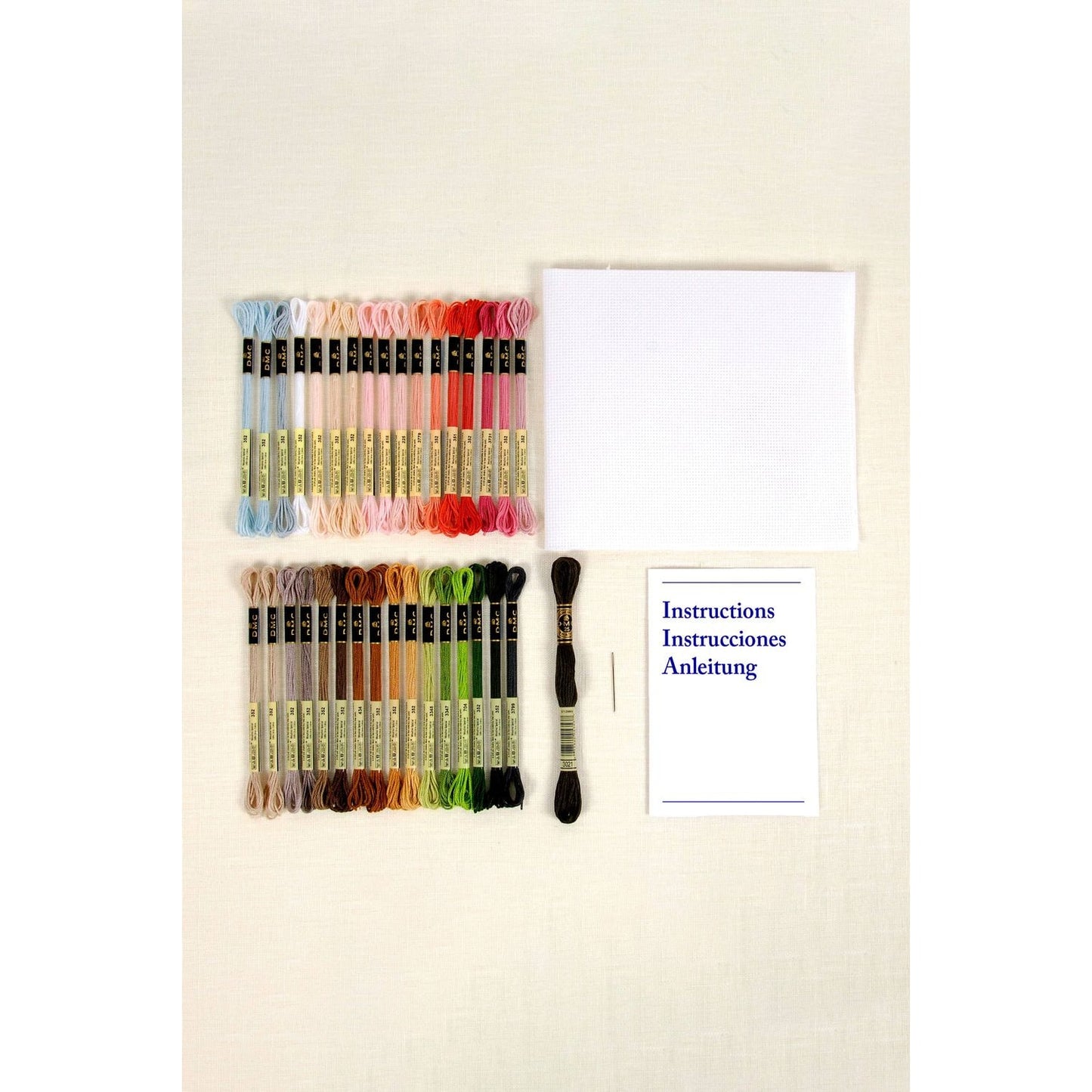 DMC embroidery kit with colorful threads, cloth, needle, and instructions featuring the Eiffel Tower design