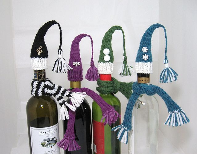 Festive wine bottle decorations workshop featuring knitted caps in various colors and designs