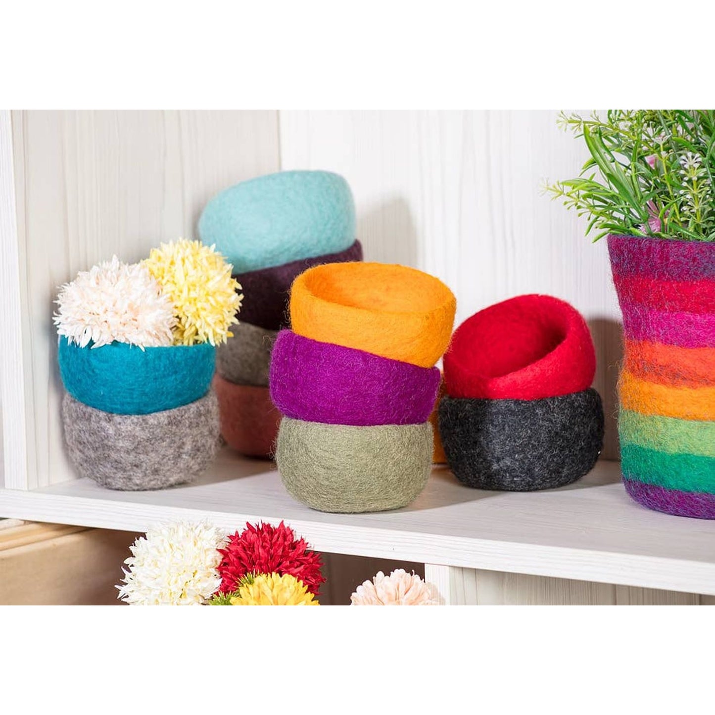 Colorful handmade yarn storage bowls in various sizes and patterns for organizing craft supplies