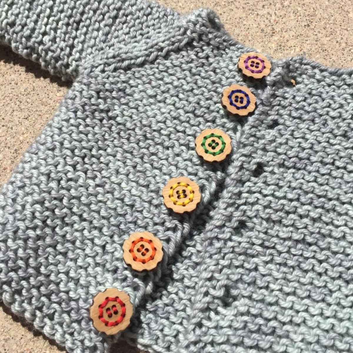 Katrinkles knitted cardigan with colorful wooden bachelor buttons flower embellishments on the front