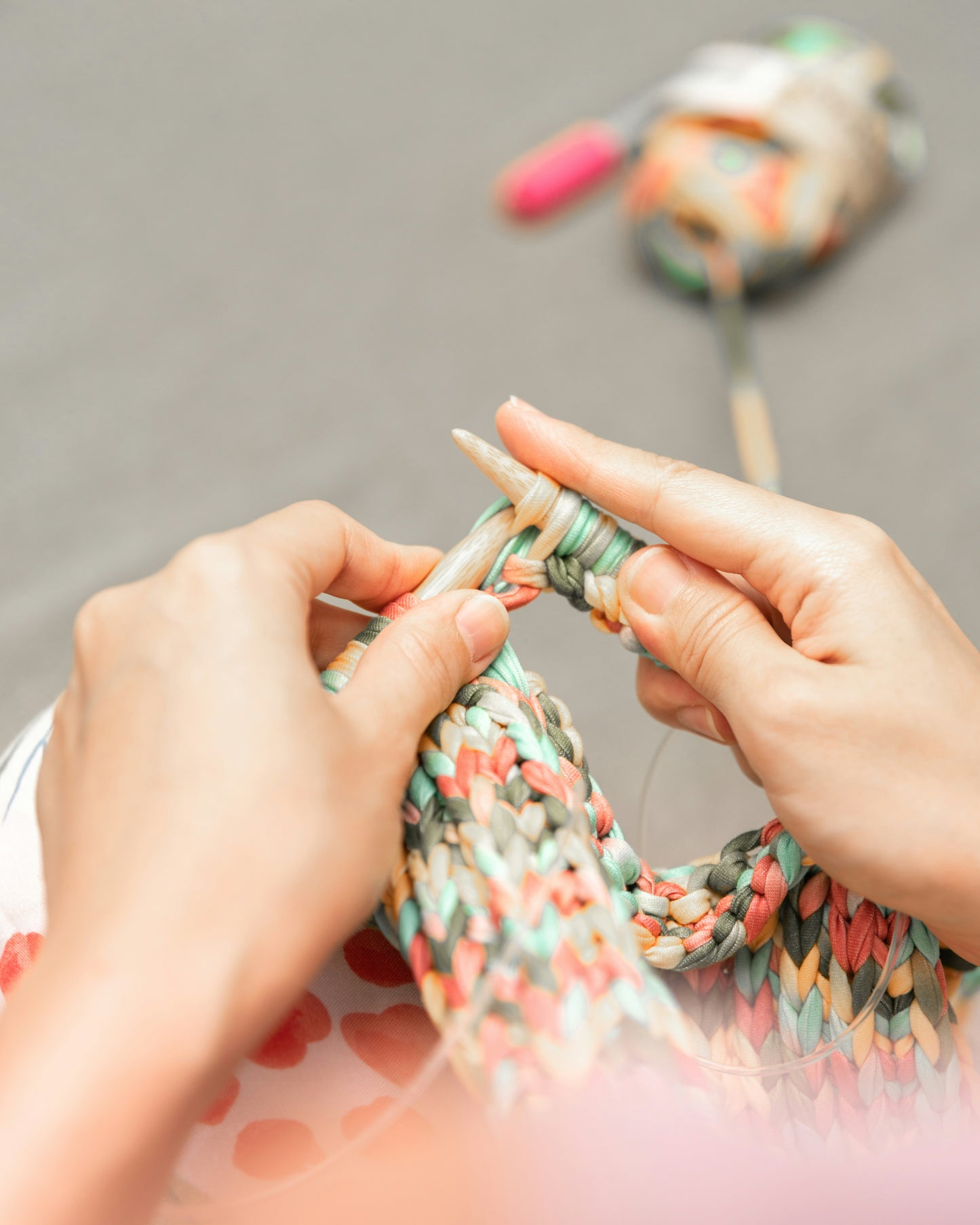 AriYARN Shop and Studio children's knitting classes near Chicago showing close up hands knitting chunky multicolor yarn