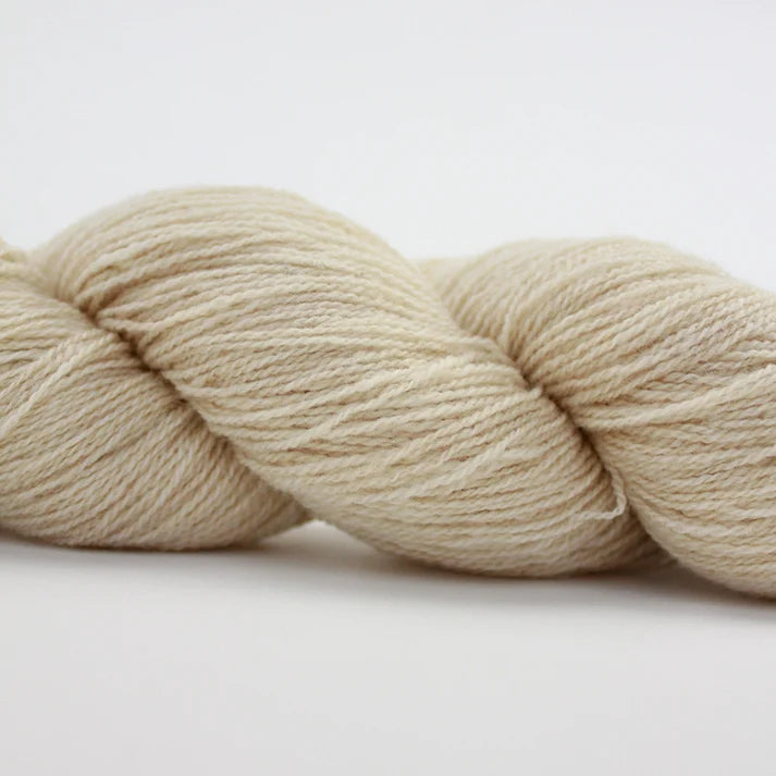 Soft cream-colored lotus yarns in a skein, perfect for knitting and crafting projects