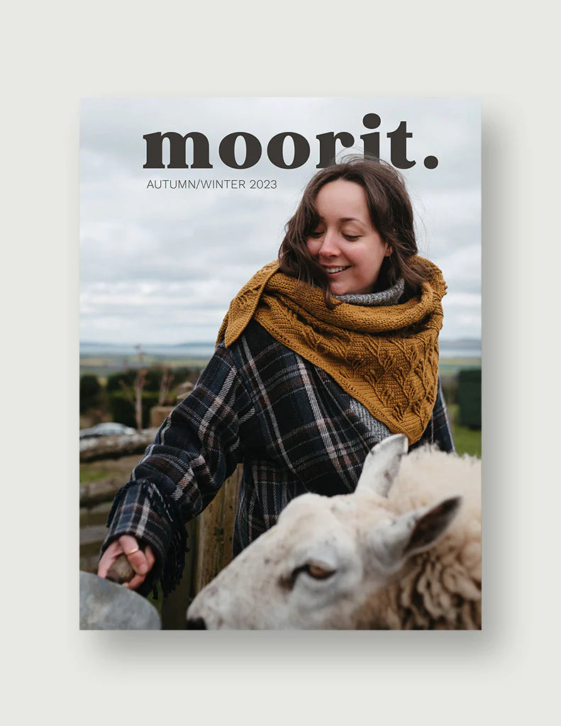 Moorit Magazine crochet patterns magazine cover woman in mustard crochet cowl plaid coat with sheep outdoors