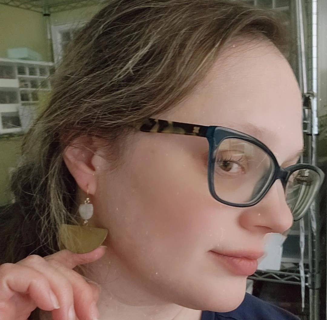 Woman wearing Sara Sela Jewelry crescent rainbow moonstone earrings closeup gold crescent and moonstone bead