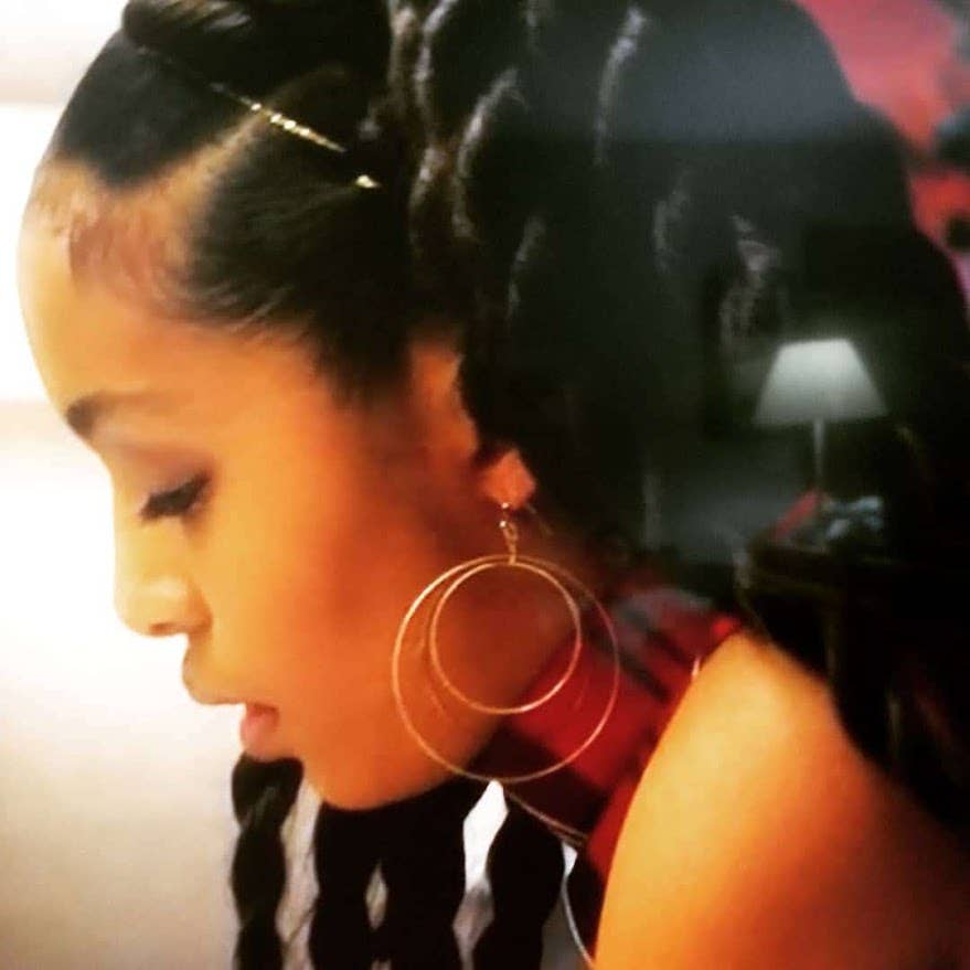 Profile of woman with braided hair wearing Sara Sela Jewelry brass circle hoop dangle earrings large gold hoops