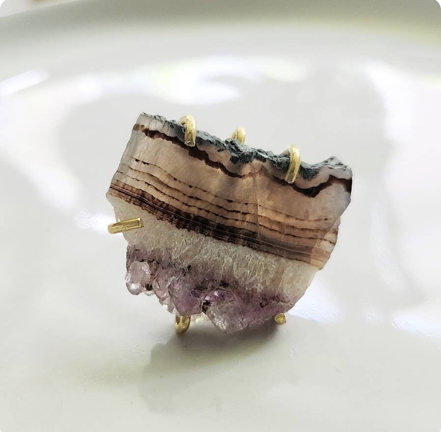 Sara Sela jewelry amethyst ring raw banded amethyst slice set in gold prong ring on white dish