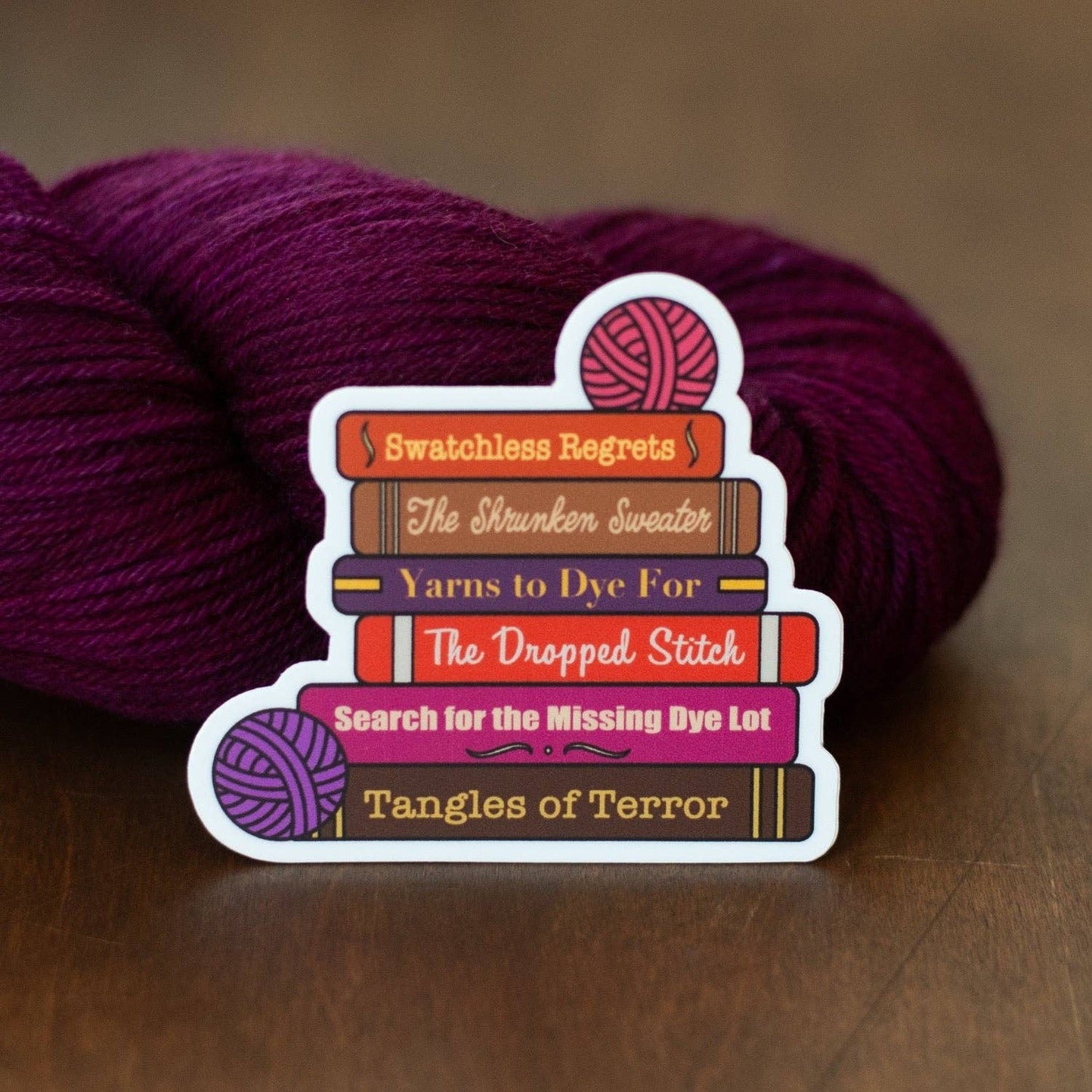 Camp Stitchwood sticker featuring colorful yarn-themed book titles and a playful design