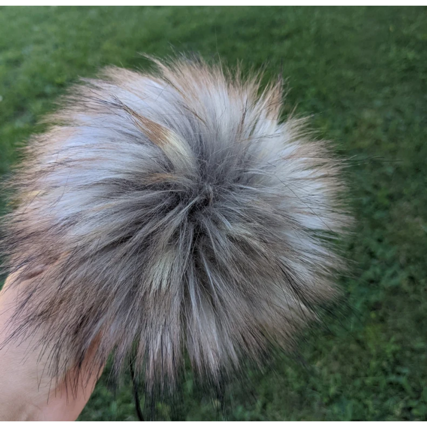 Fluffy stormy grey pom pom for crochet hats in a natural outdoor setting