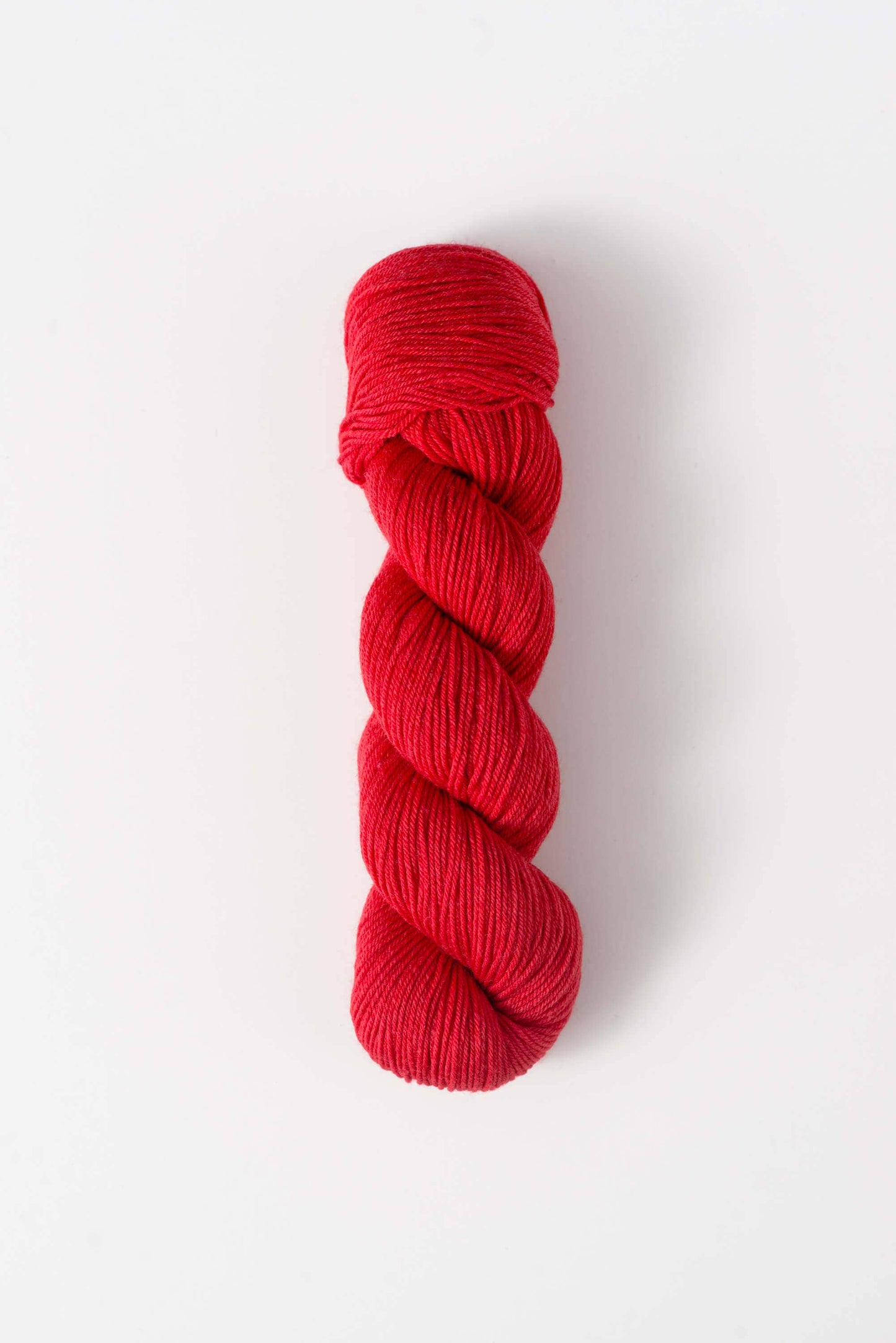 Quince & Co. superwash merino fingering yarn in vibrant red color skein