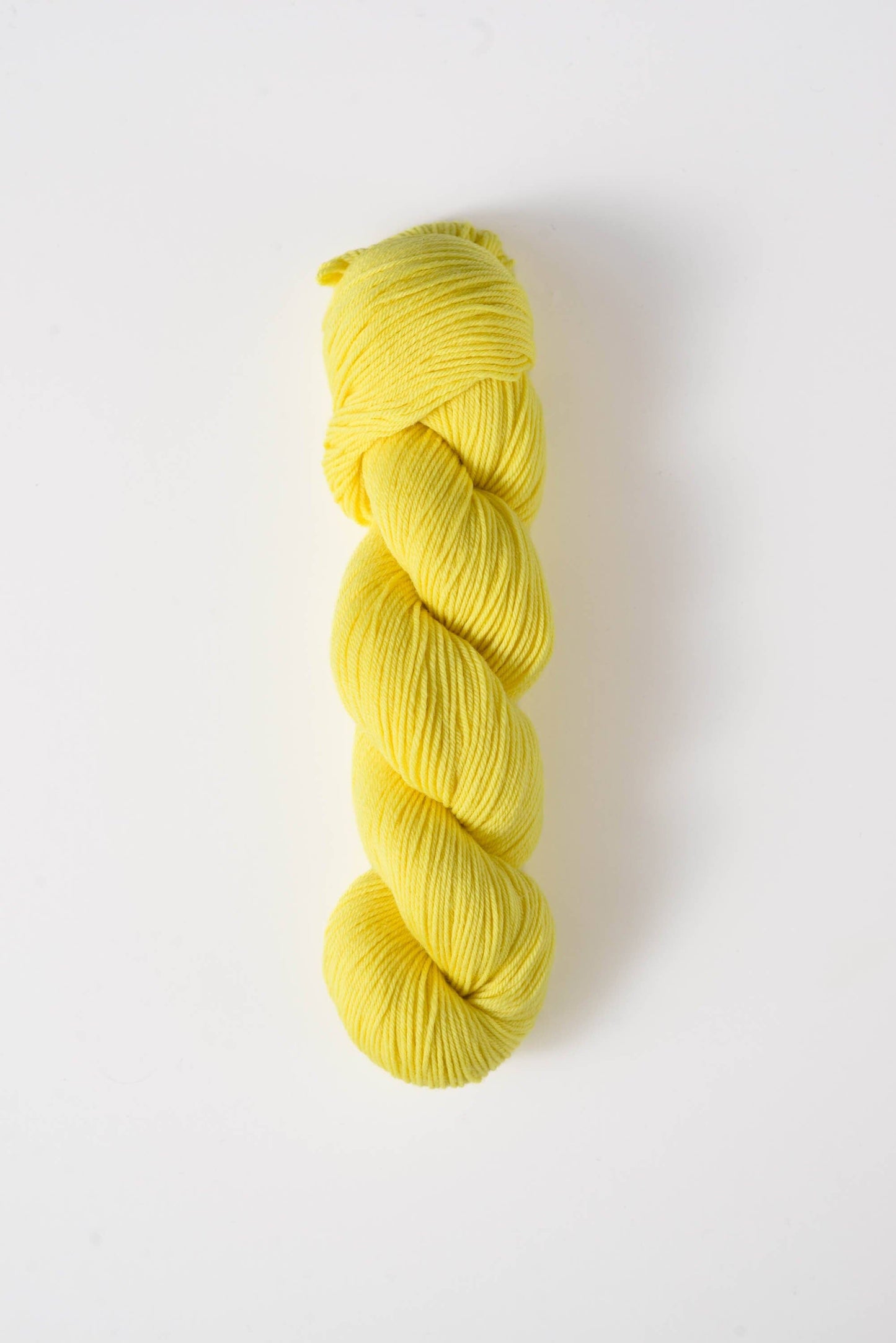 Yellow skein of Quince and Co superwash merino fingering yarn for knitting and crochet projects