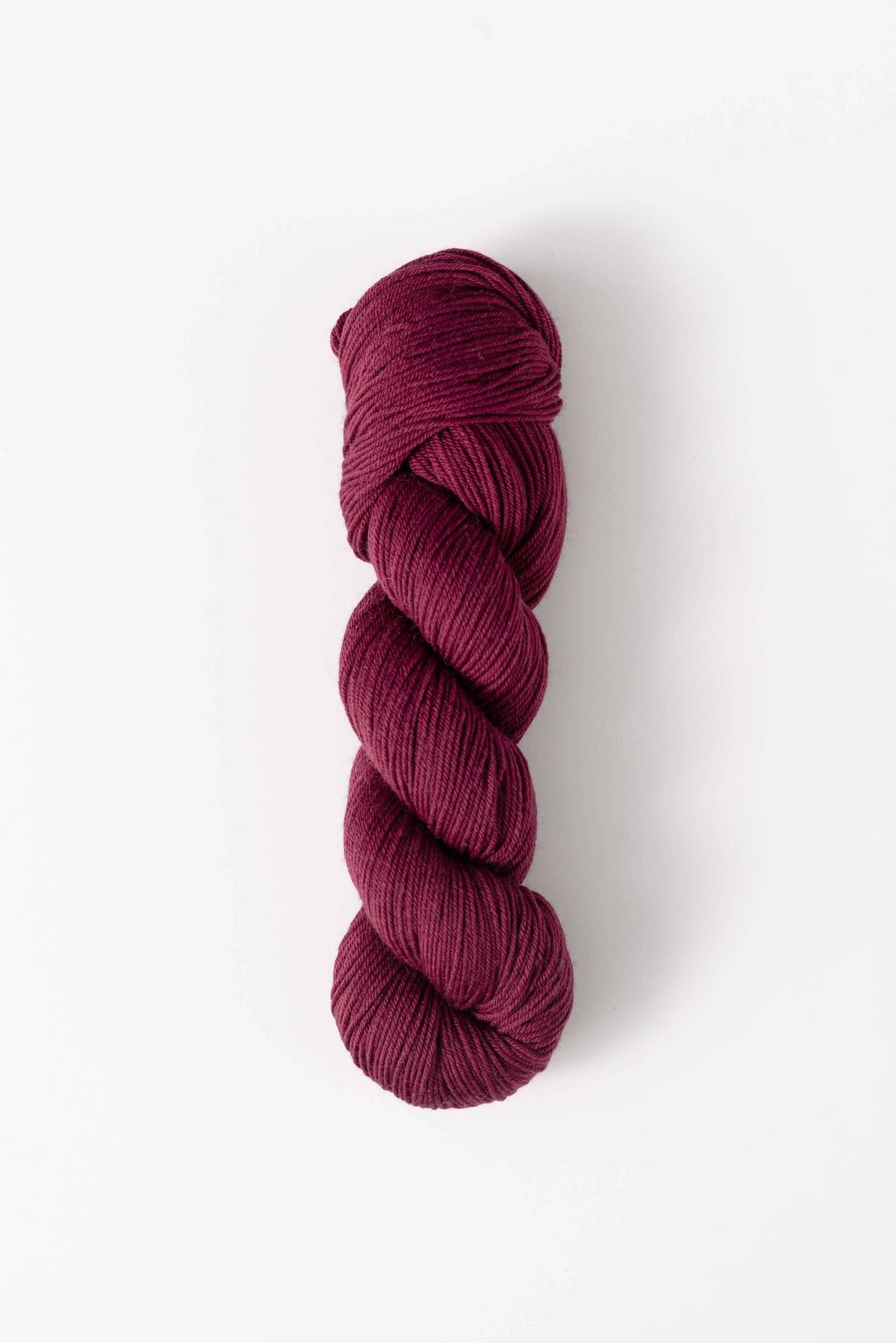 Quince & Co. superwash merino fingering yarn in deep berry color skein for knitting and crochet