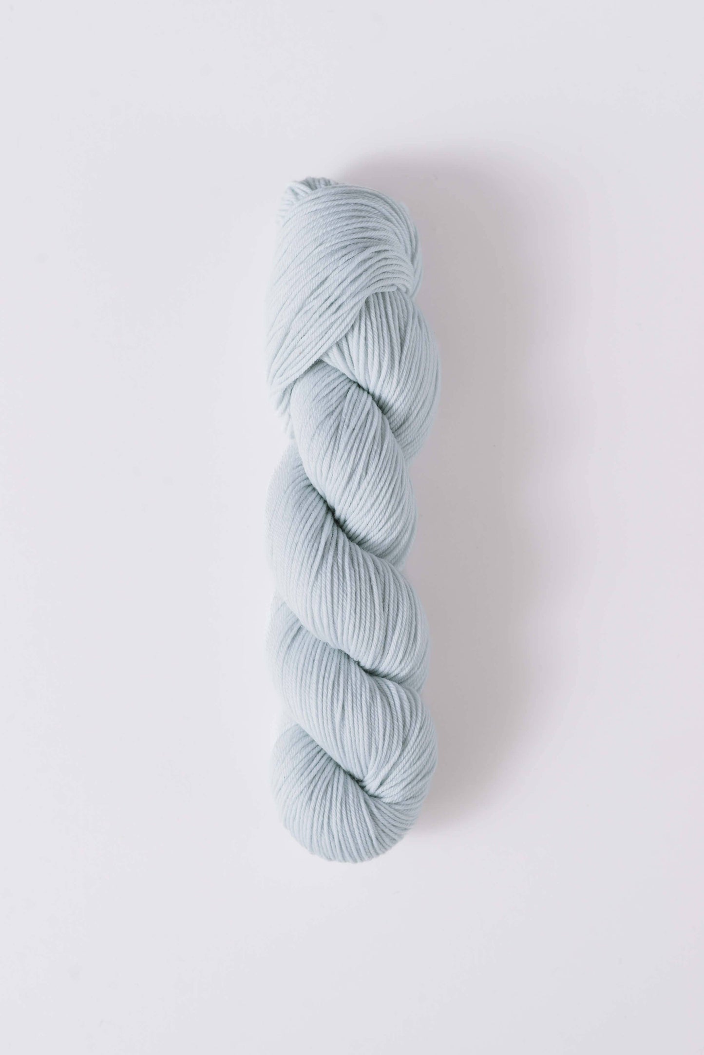 Quince & Co superwash merino fingering yarn in soft pale blue twisted skein