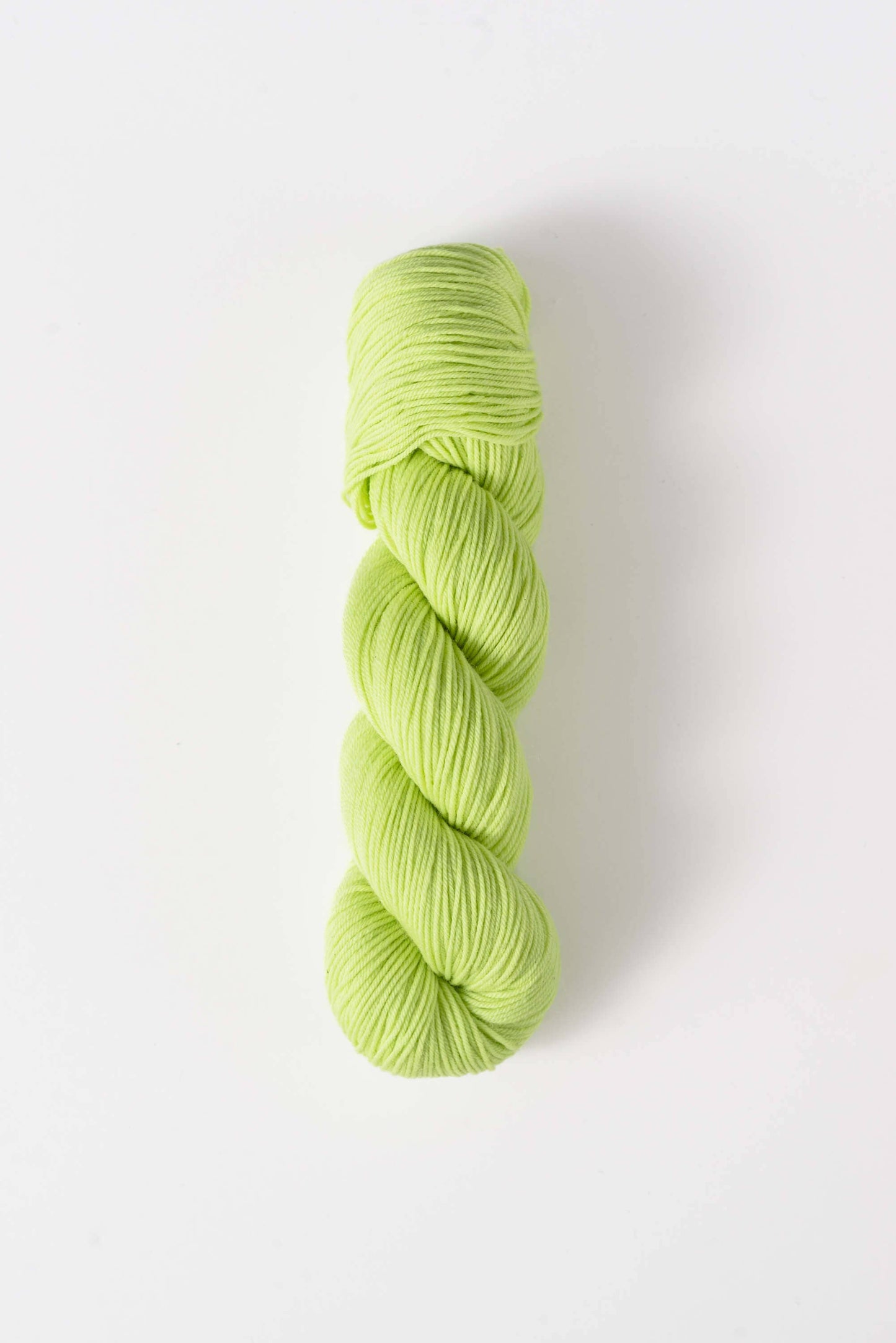 Quince & Co. superwash merino fingering yarn in light green shade twisted skein