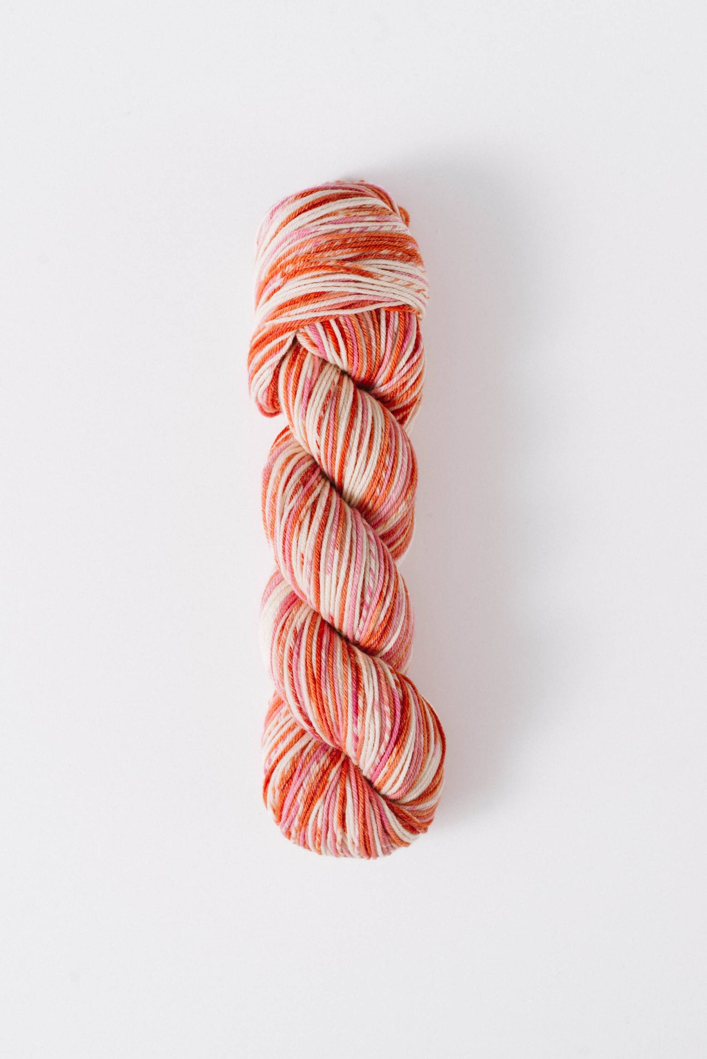Quince and Co superwash merino fingering yarn in a variegated orange and cream colorway