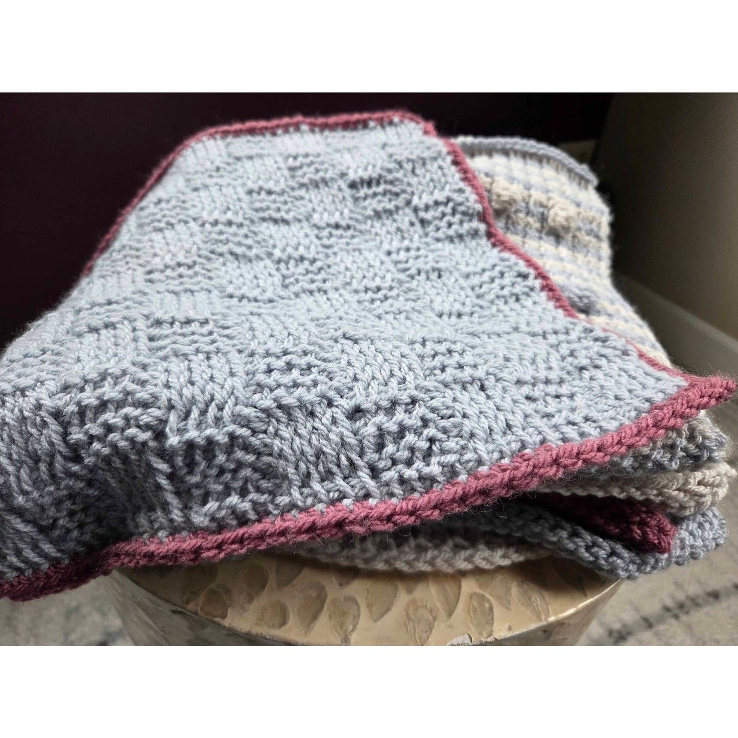 Handmade Tunisian crochet blanket in soft gray with maroon trim, perfect for cozy warmth.