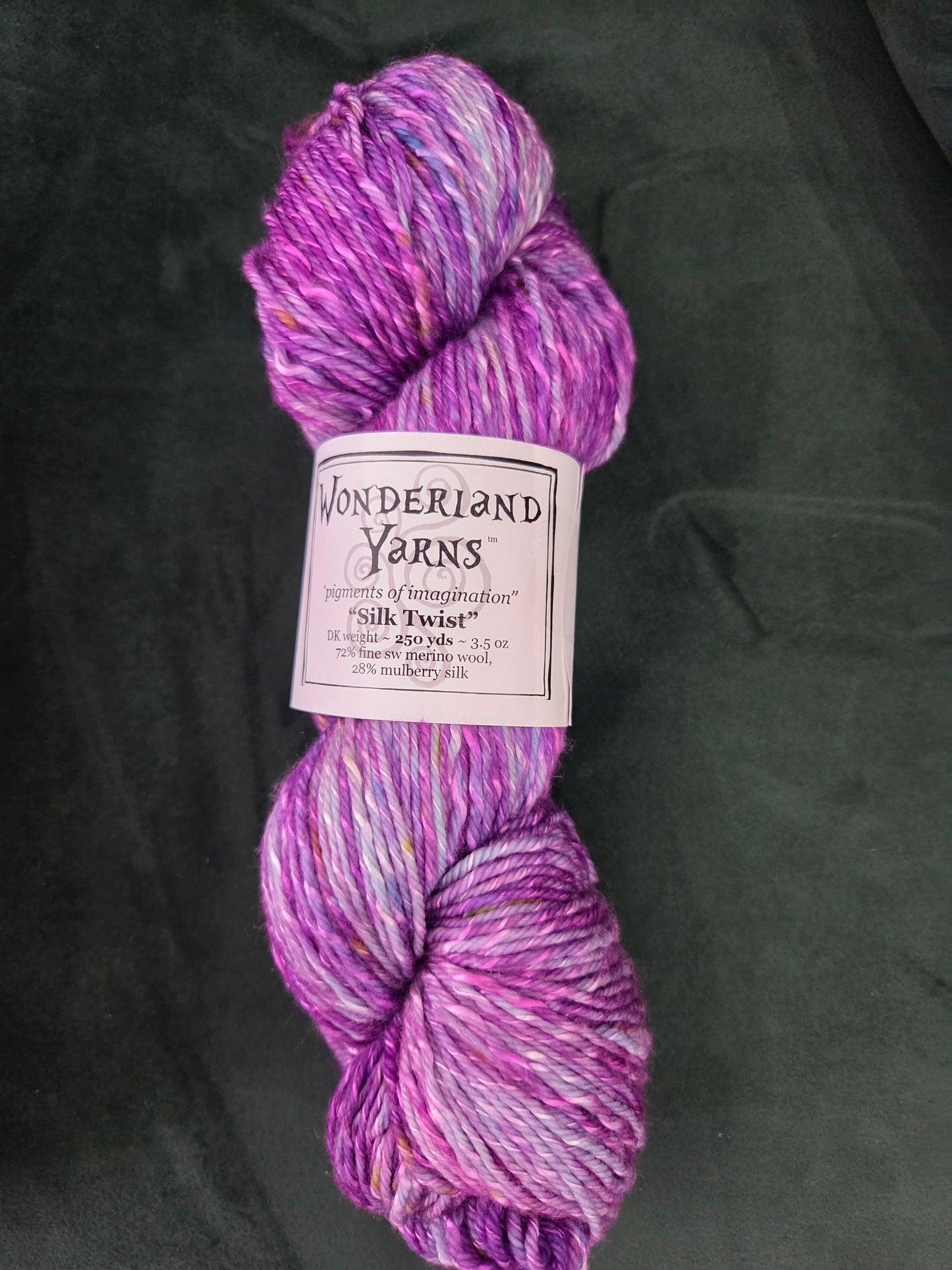 Frabjous Fibers Wonderland Yarns Silk Twist hand dyed variegated purple and pink yarn skein on black background