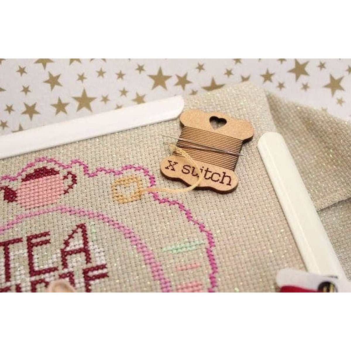 Square granny square pattern from A Needle Runs Through It with decorative thread holder and fabric background
