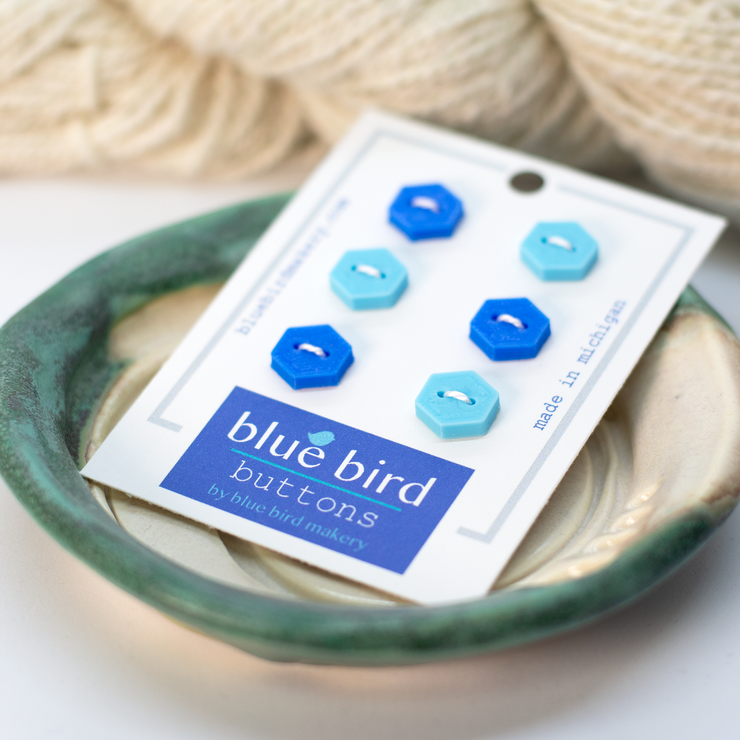 Blue Bird Makery button set with six hexagon buttons in blue and turquoise on a display card