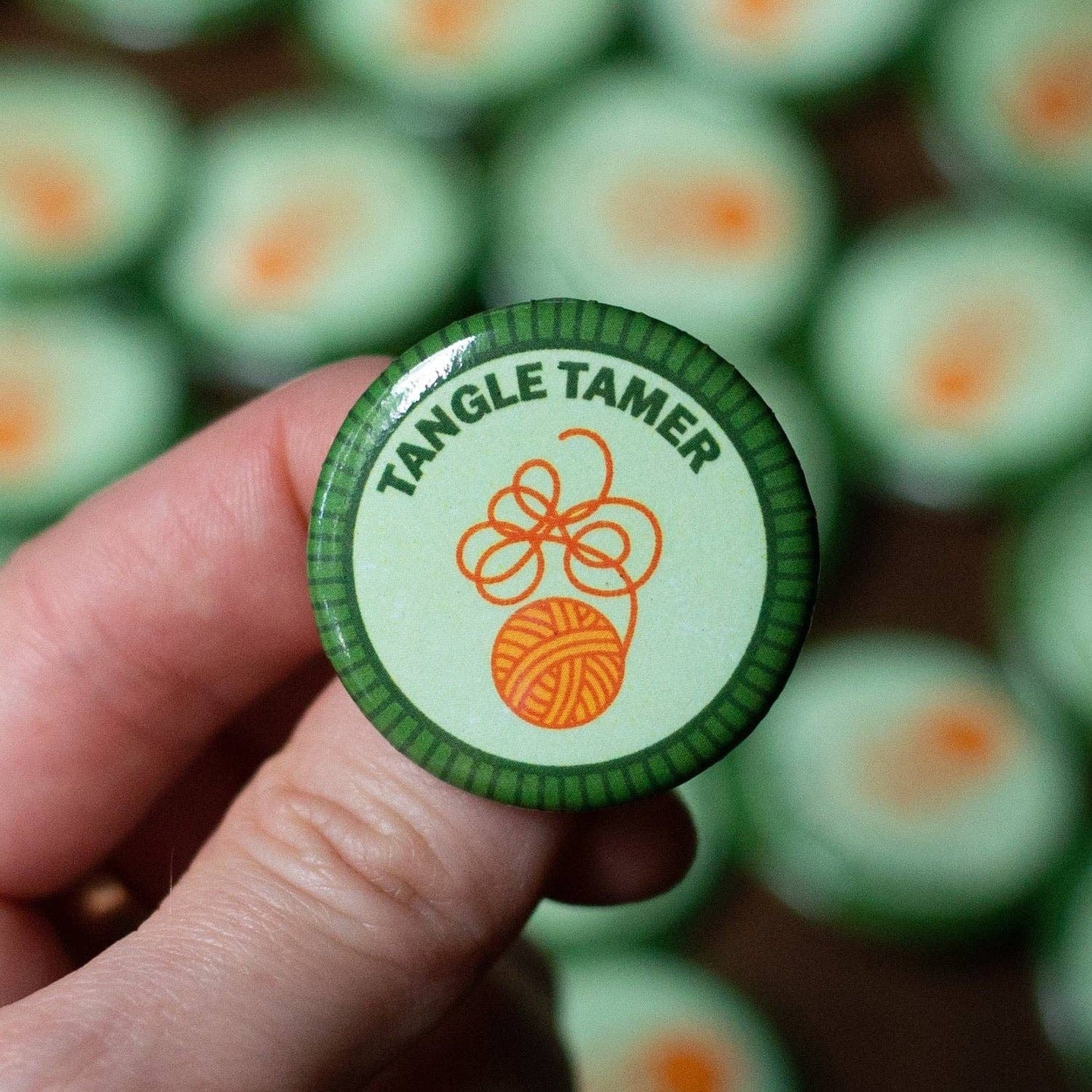 Camp Stitchwood Tangle Tamer Button featuring a yarn ball illustration for knitting knits enthusiasts