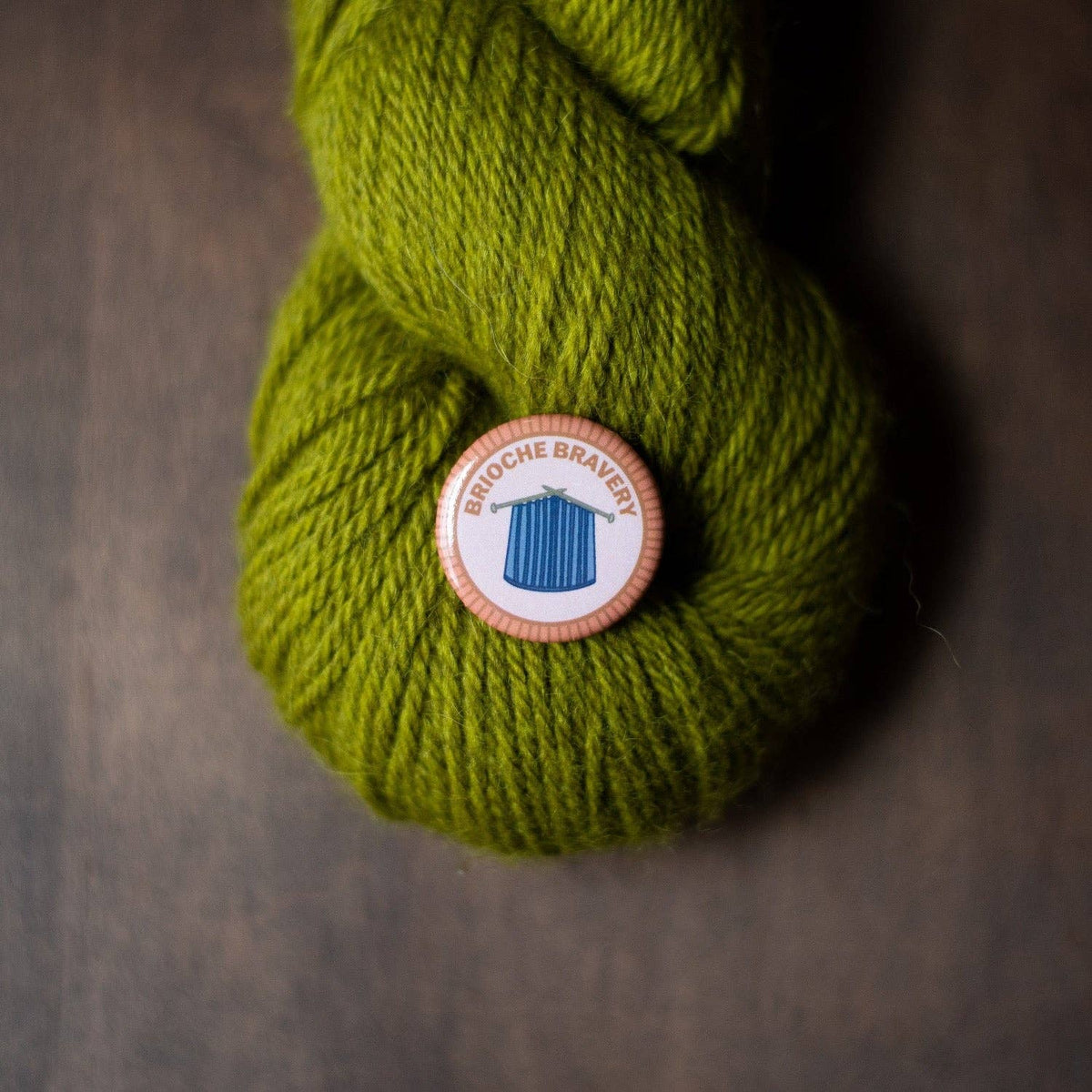 Brioché Bravery Badge Pin on Olive Green Yarn, a merit badge required for eagle