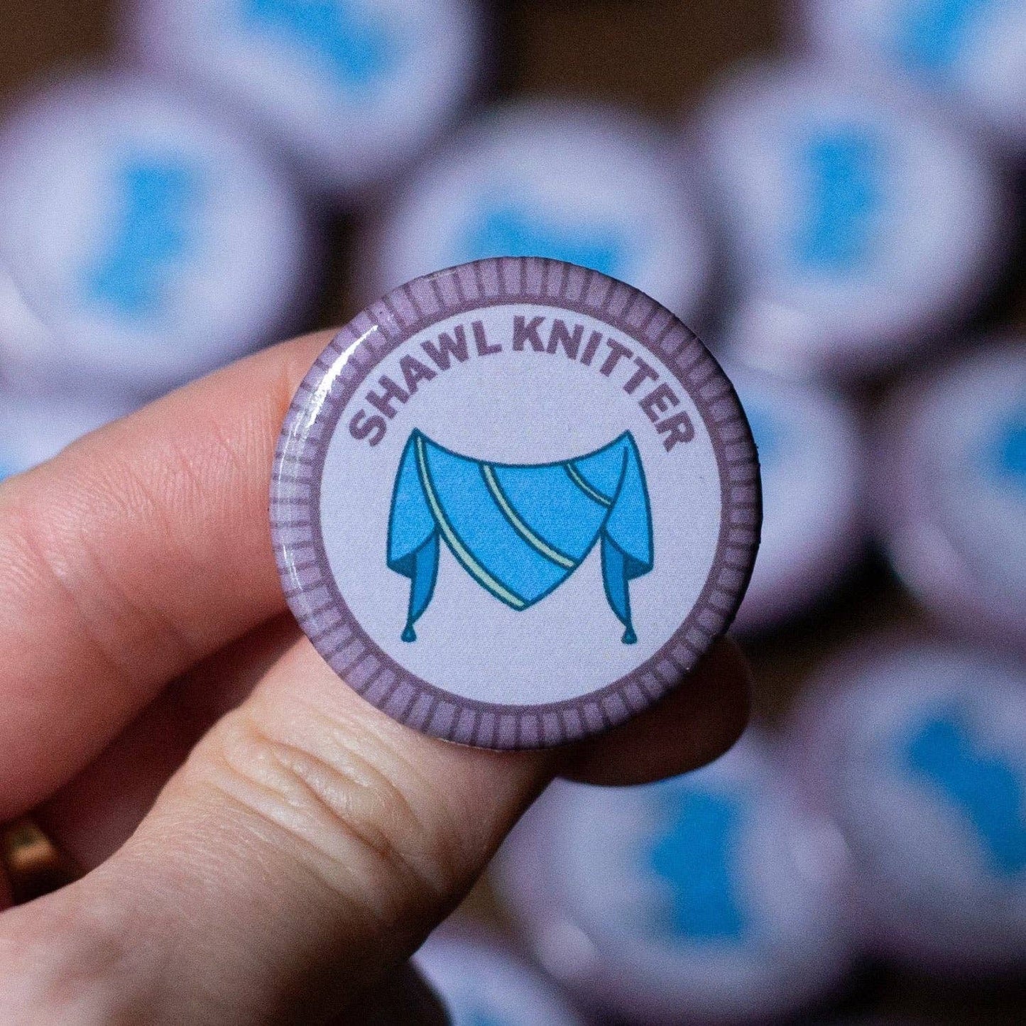 Shawl Knitter merit badge required for eagle displayed in a hand, showcasing blue design