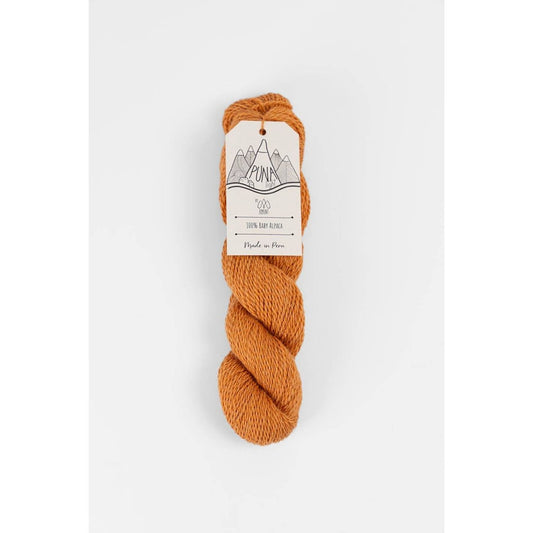 Berroco Amano Puna Light baby alpaca yarn in warm rust orange twisted skein with label