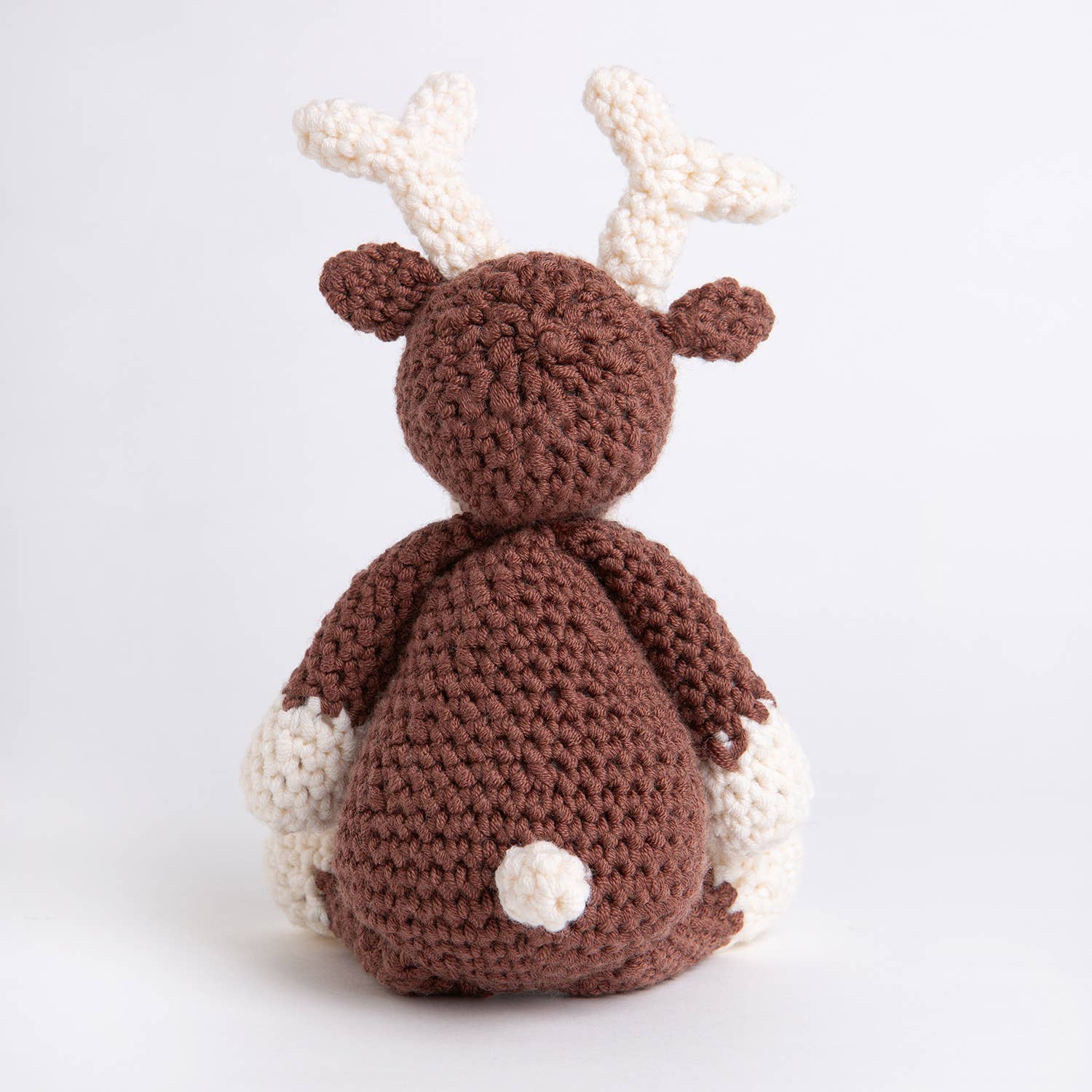 Belle the Reindeer crochet pattern brown amigurumi reindeer with cream antlers and paws shown from back on white background