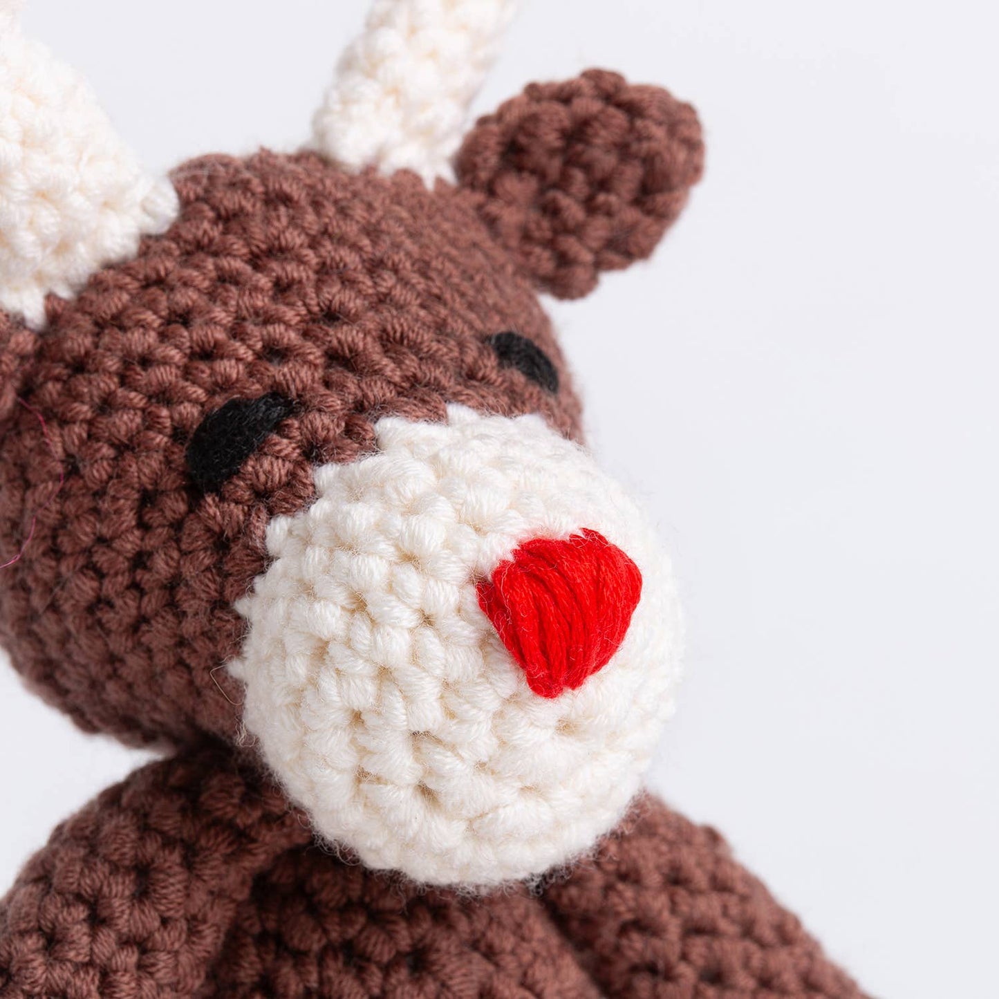 Close up of Wool Couture Company brown crocheted reindeer with white snout and red heart nose Belle the Reindeer crochet pat…
