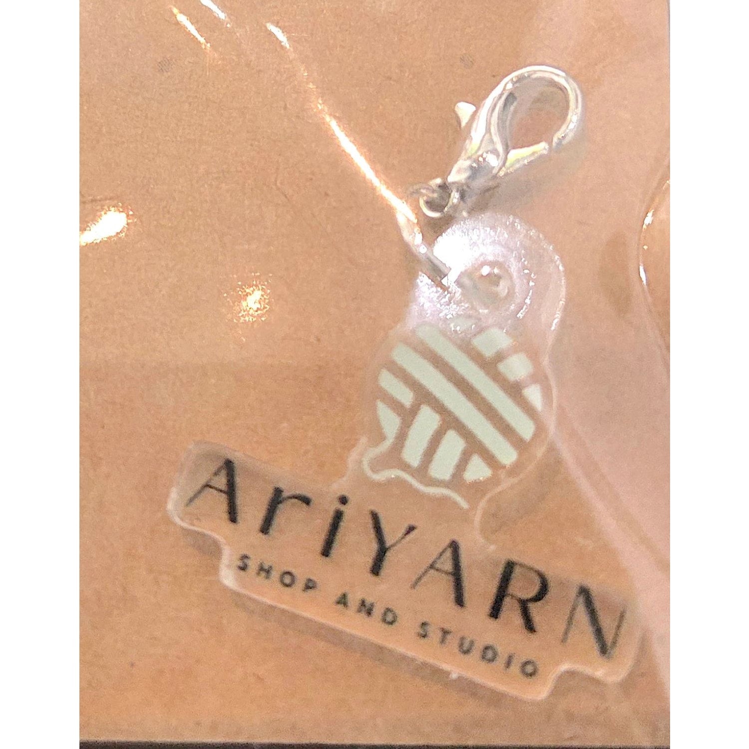 AriYARN Shop and Studio handmade yarn stitch marker with a yarn ball design and metal clasp