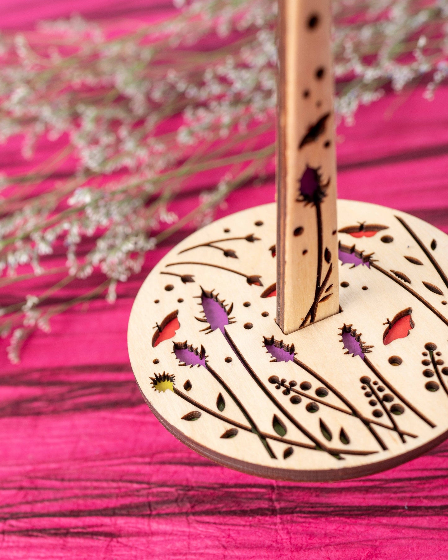 lemonwood knitting accessory wooden spindle with laser cut floral design and colorful inlays on pink background