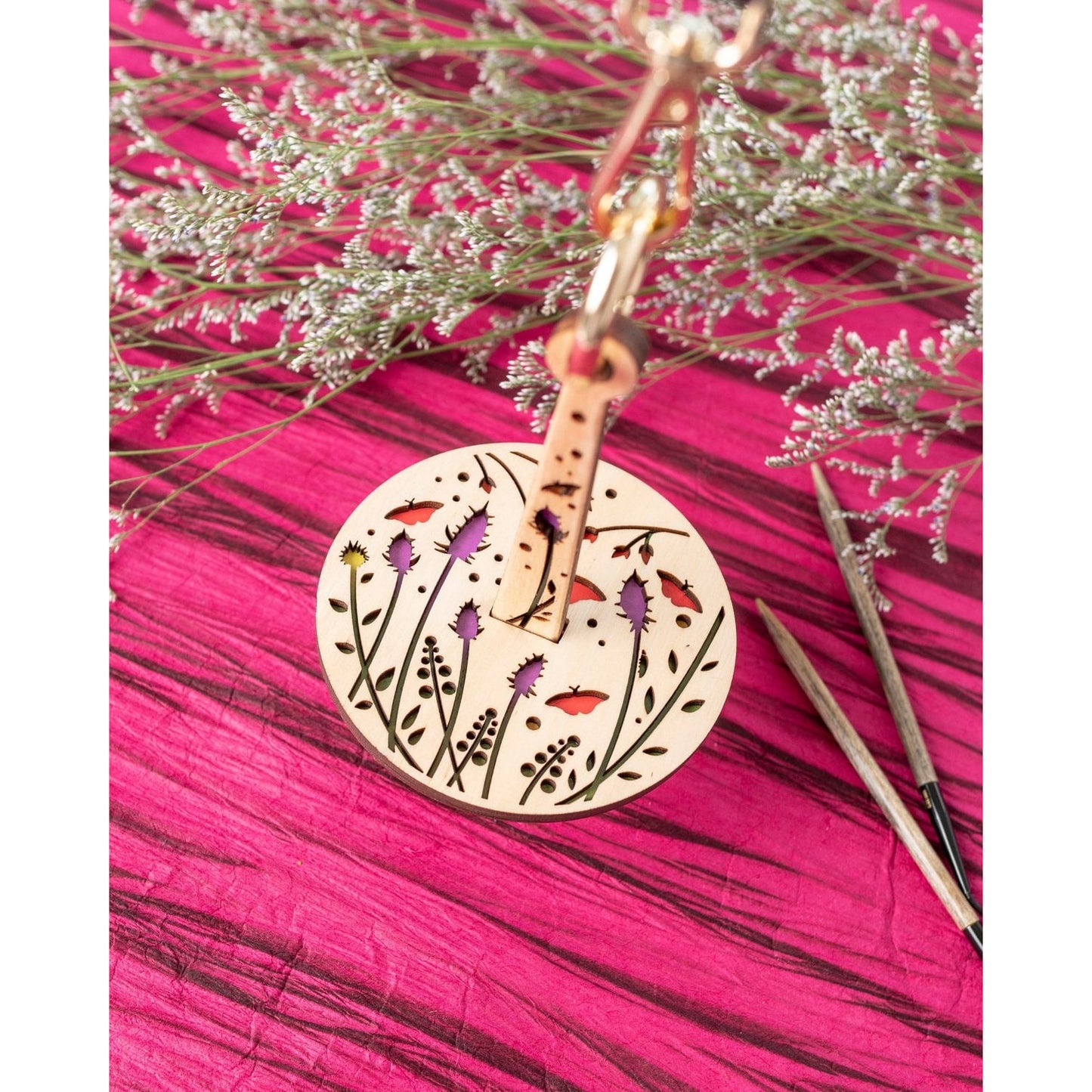 Round laser cut floral wooden stitch marker on clasp with knitting needles lemonwood knitting accessory for knitters