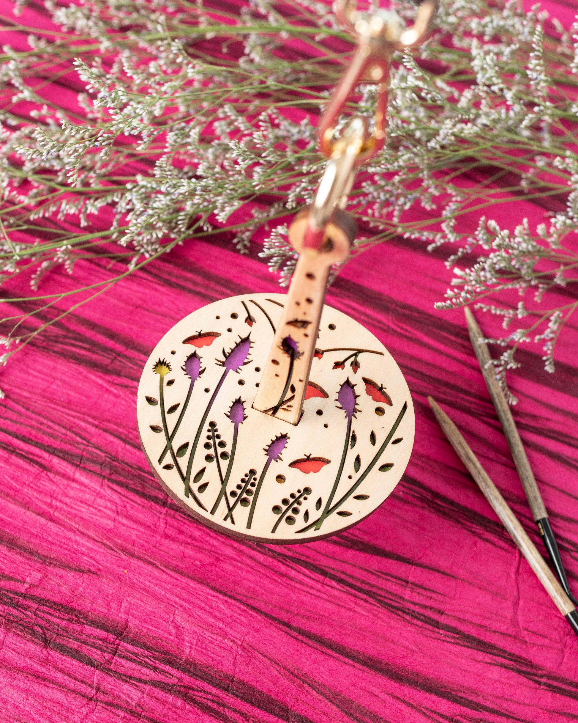 Round laser cut floral wooden stitch marker on clasp with knitting needles lemonwood knitting accessory for knitters