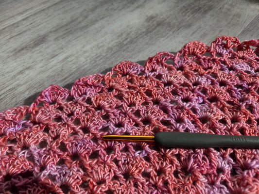 Ergonomic crochet hook on pink variegated shell stitch swatch for private crochet teacher Chicago area lessons
