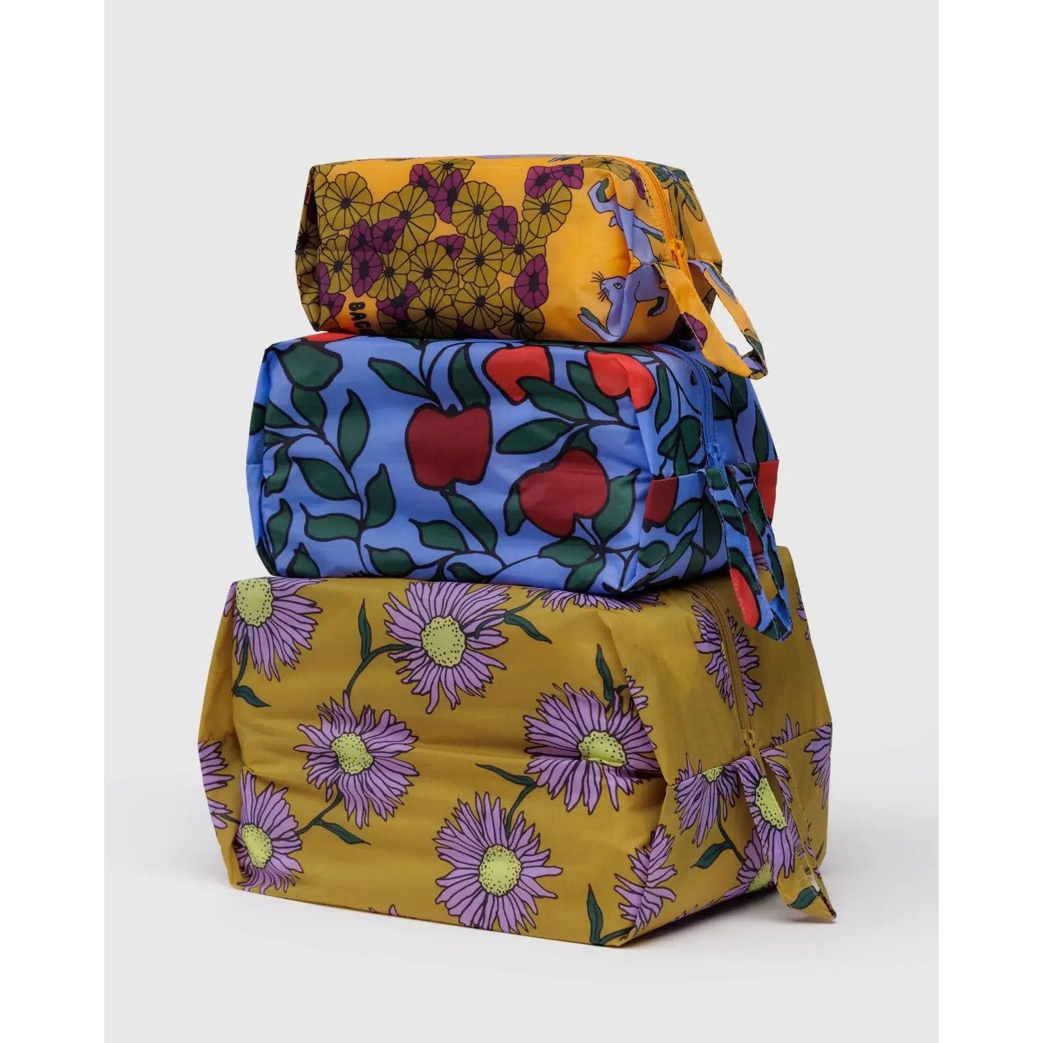 Baggu 3D Zip Set in colorful floral and fruit patterns stacked together for convenient storage