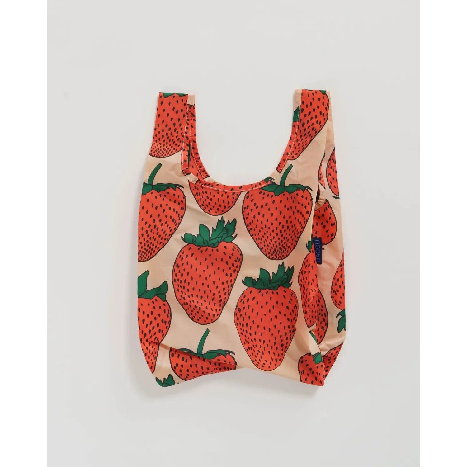 Baby Baggu reusable bag with a vibrant strawberry print on a peach background