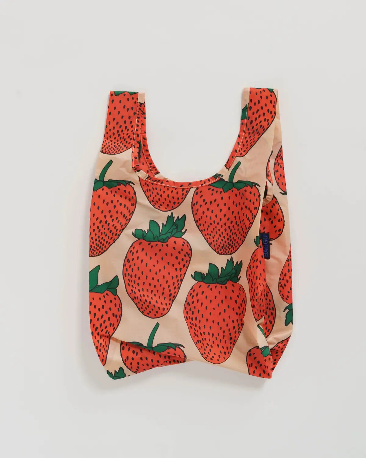 Baby Baggu reusable bag with a vibrant strawberry print on a peach background
