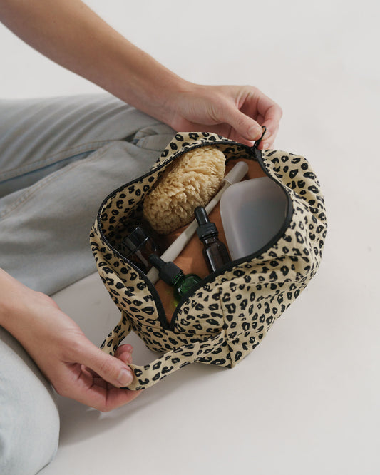 Baggu Dopp Kit in leopard print, showcasing organized skincare and grooming essentials inside
