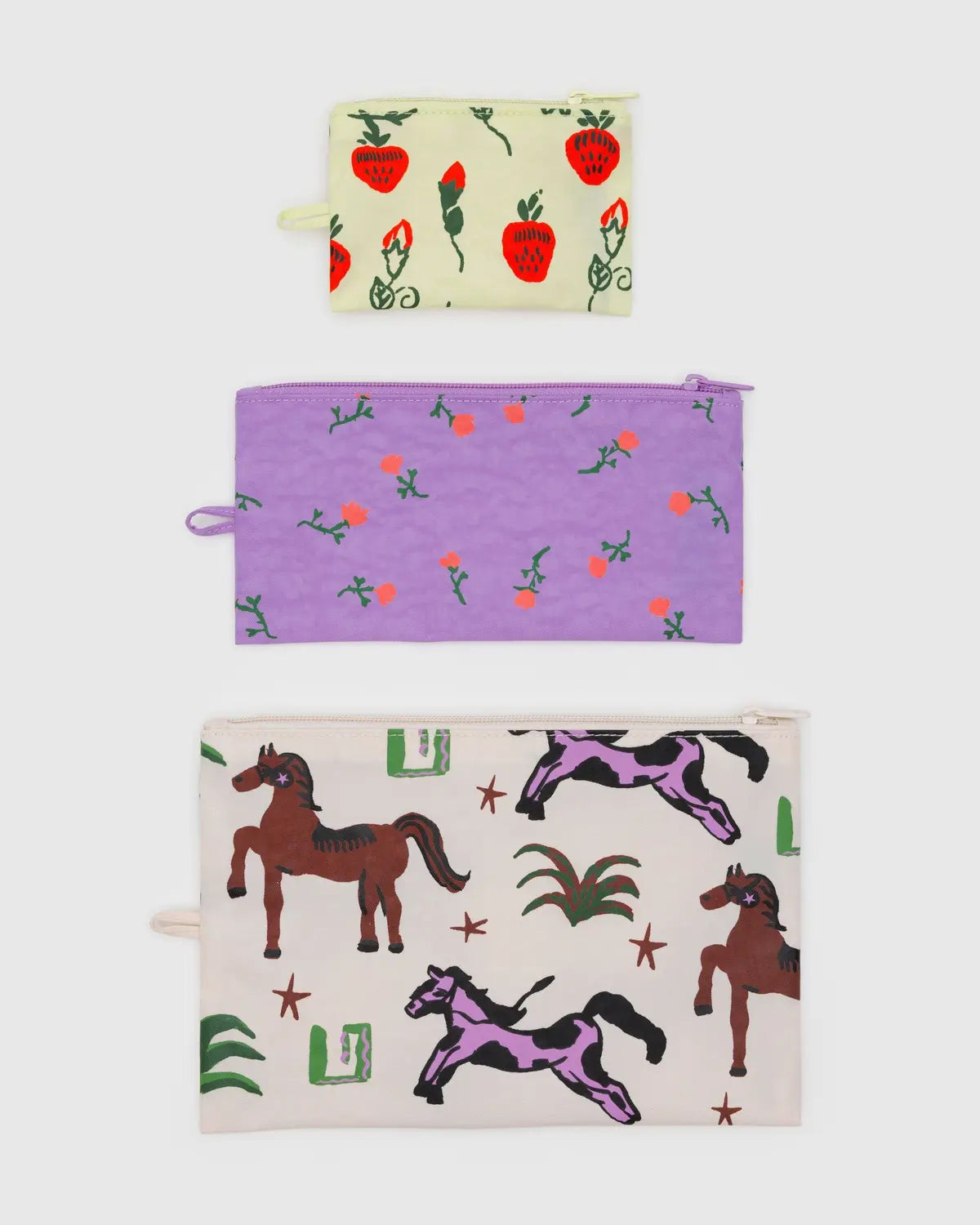Baggu flat pouch set featuring three colorful pouches with strawberry, horse, and floral designs