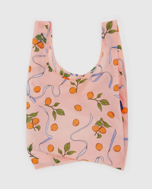 Baggu standard reusable bag in peach with orange and ribbon print for eco-friendly shopping
