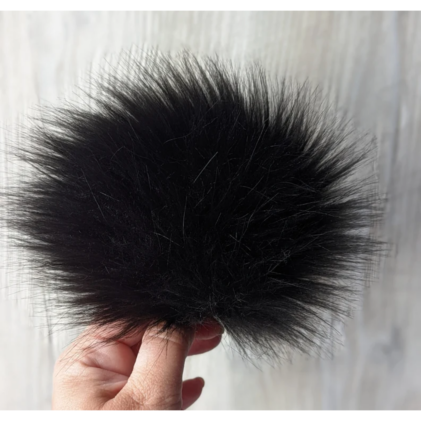 Black faux fur pom pom for hats, offering a soft and stylish accent for winter accessories