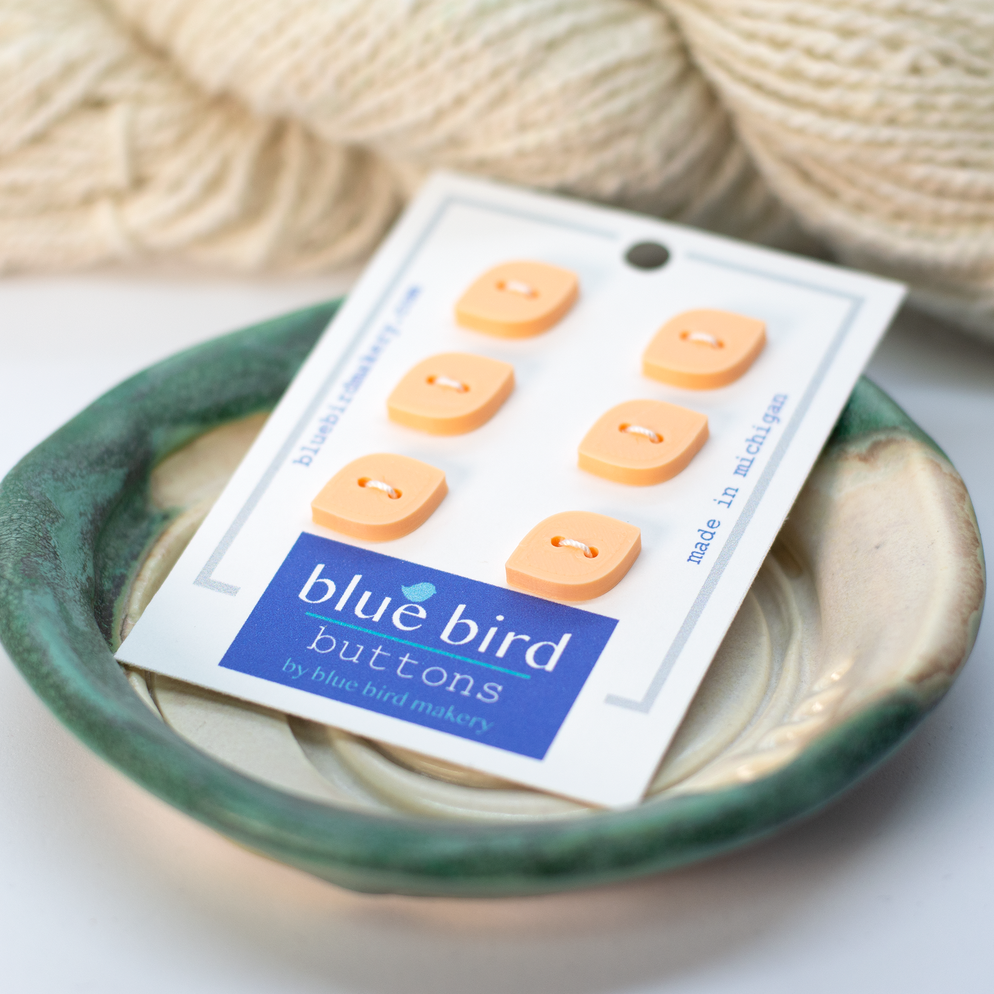 Pack of 12mm blue bird buttons in soft peach color perfect for sewing and crafting projects