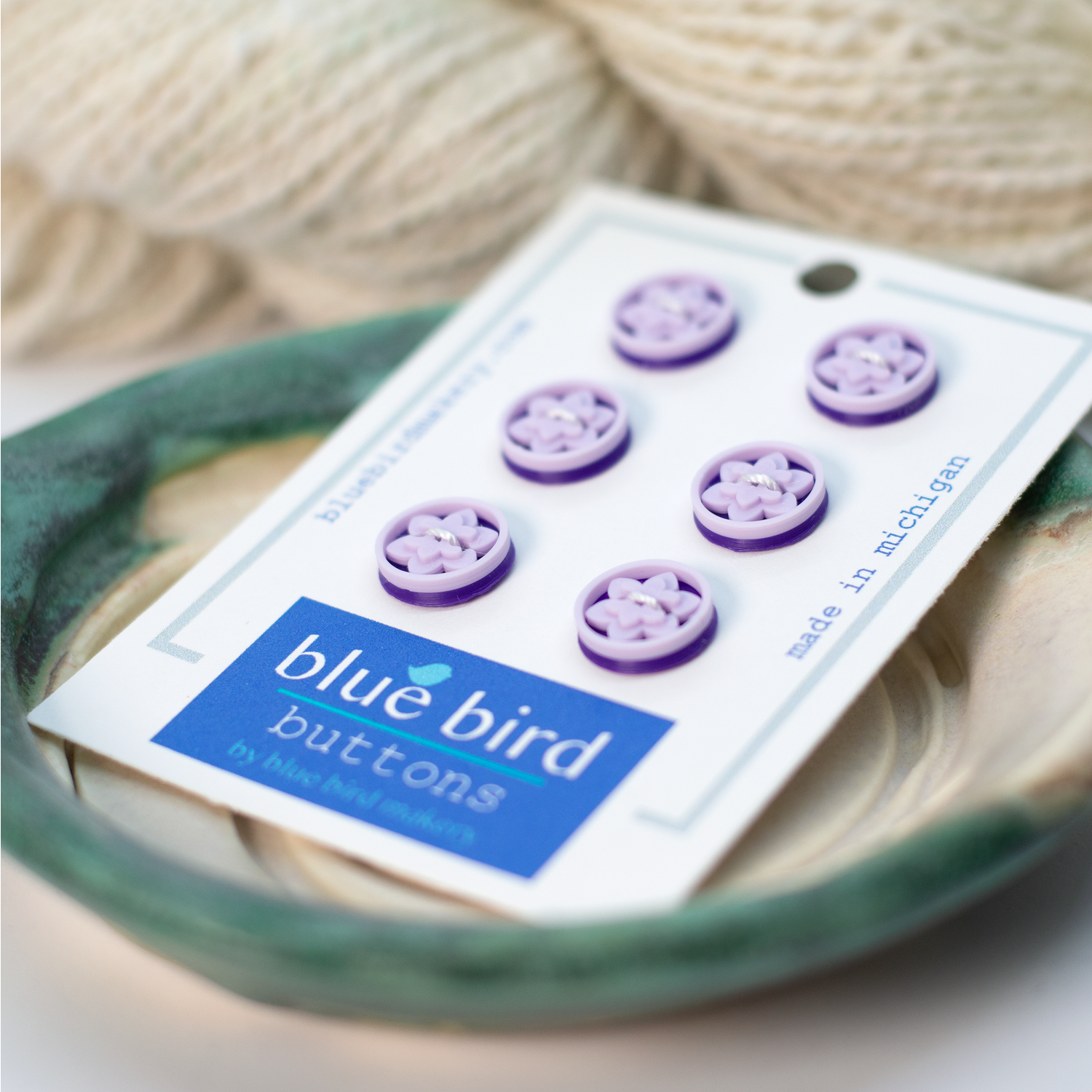 Pack of 6 purple 12mm lotus buttons for knitting on a display card by Blue Bird Makery