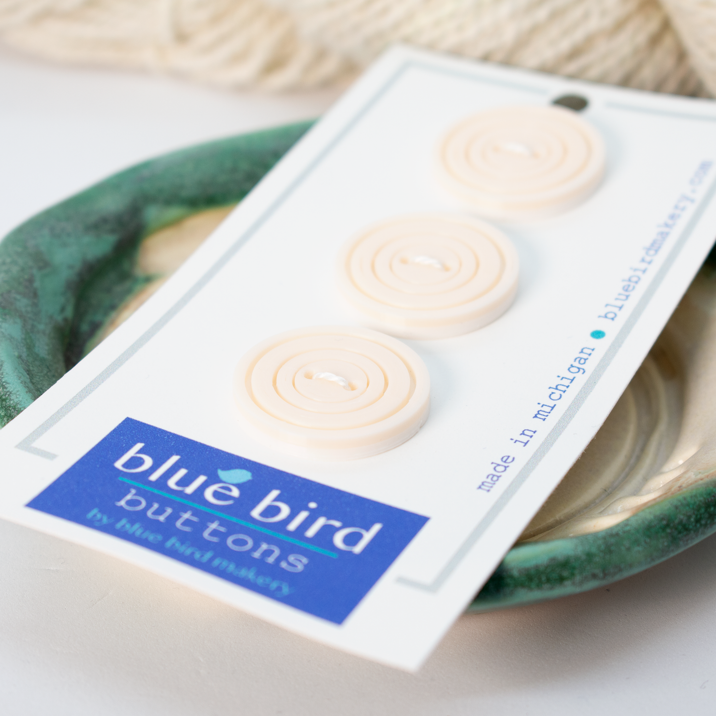 Three cream blue bird makery buttons on a card for sewing and crafting projects