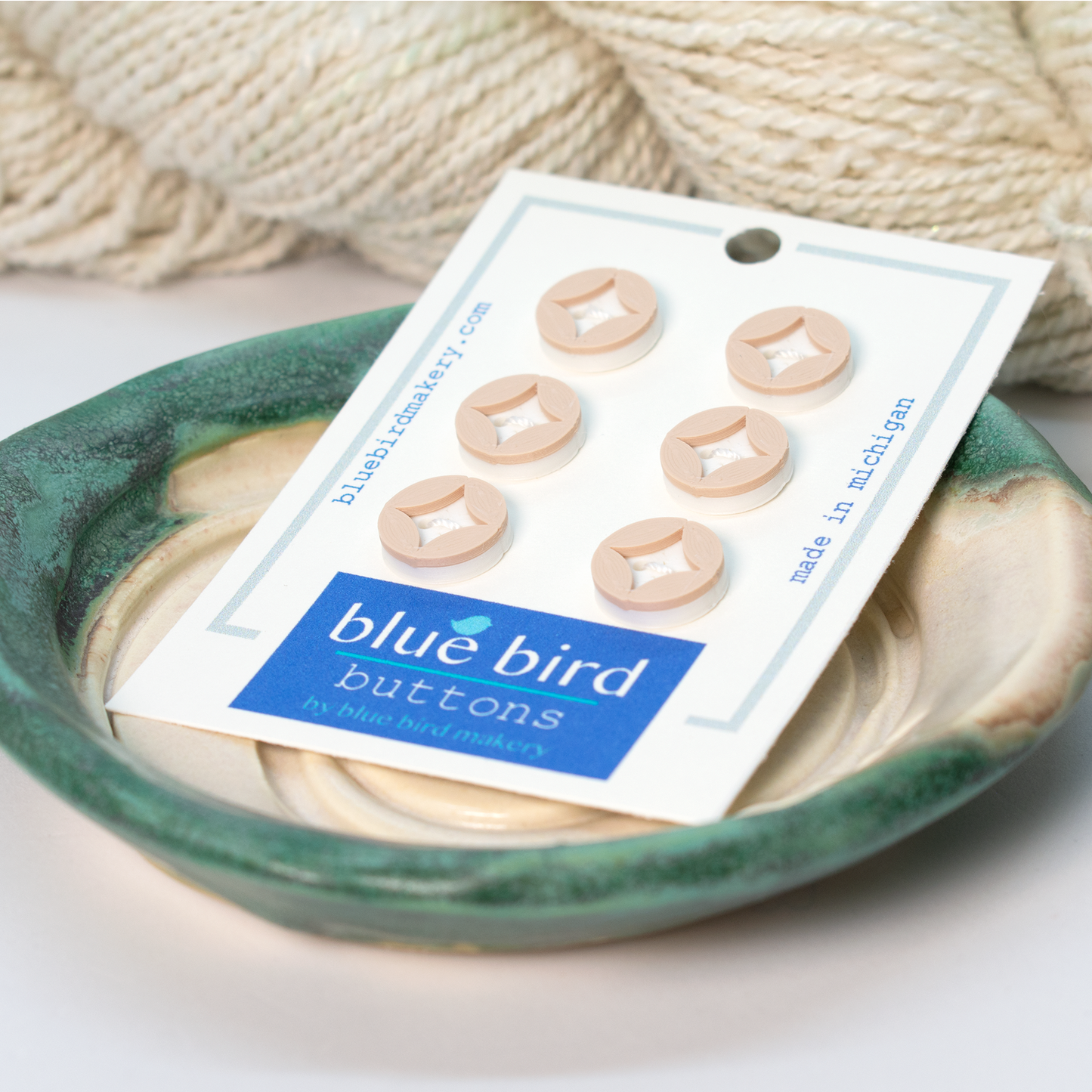 Blue Bird Makery craft supplies button set in cream color displayed on a decorative dish