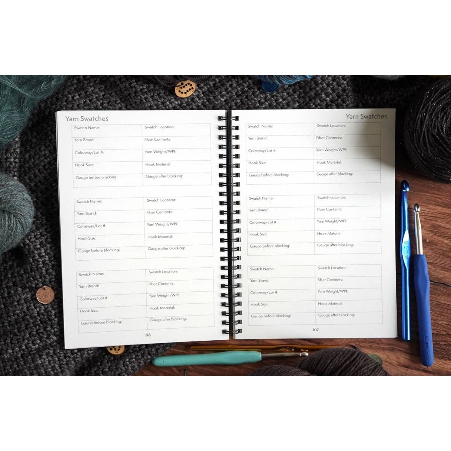 crochet pattern organizer notebook open to yarn swatches page with spiral binding yarn skeins crochet hooks and stitch marke…