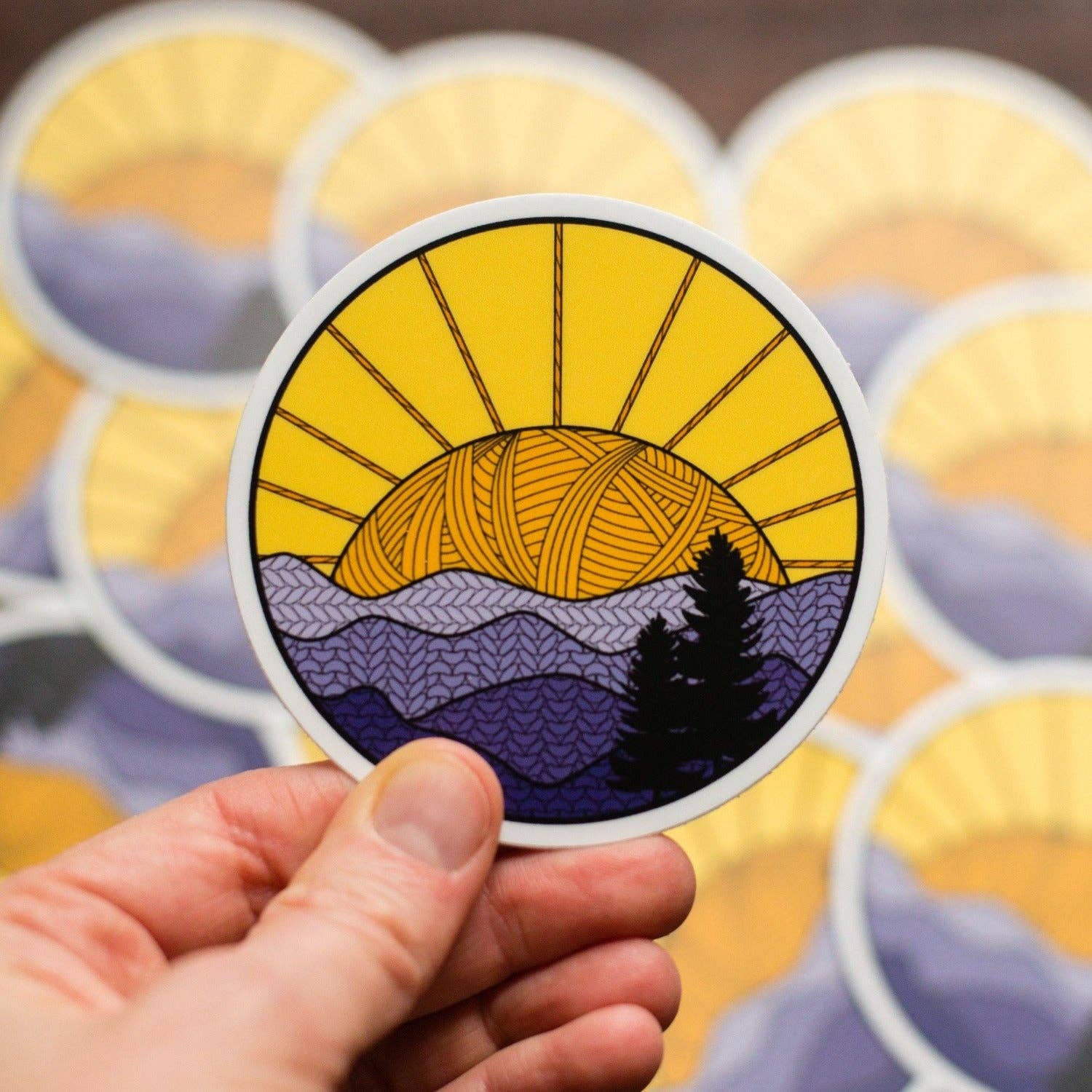Colorful camp sticker featuring a sunset over mountains with intricate designs and vibrant colors