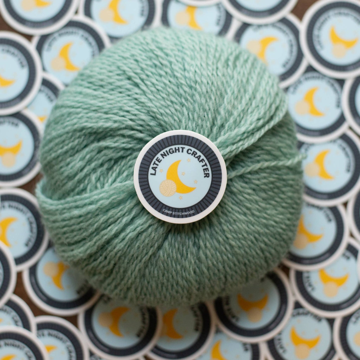 Mint green yarn ball surrounded by name badge sticker featuring a moon design