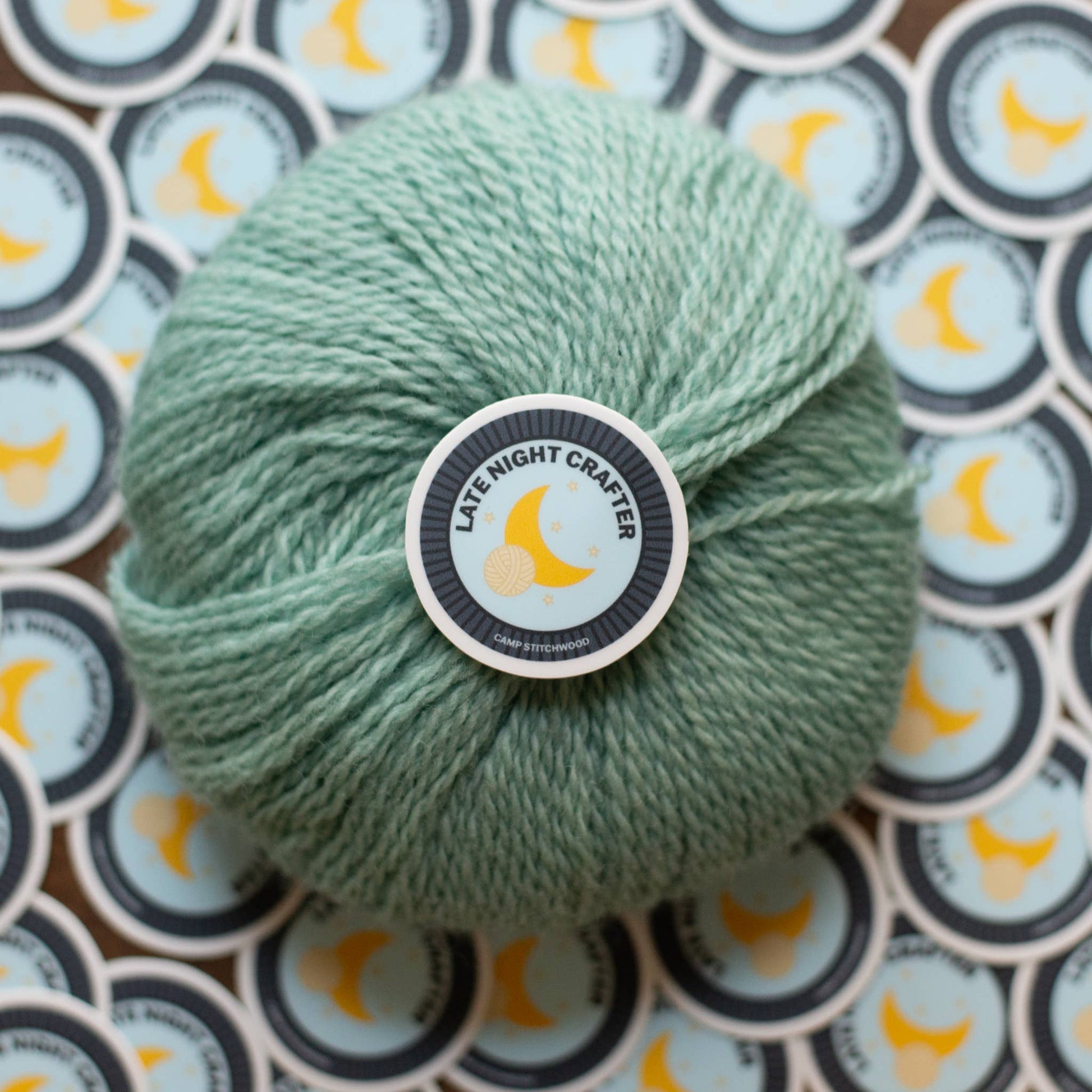 Mint green yarn ball surrounded by name badge sticker featuring a moon design